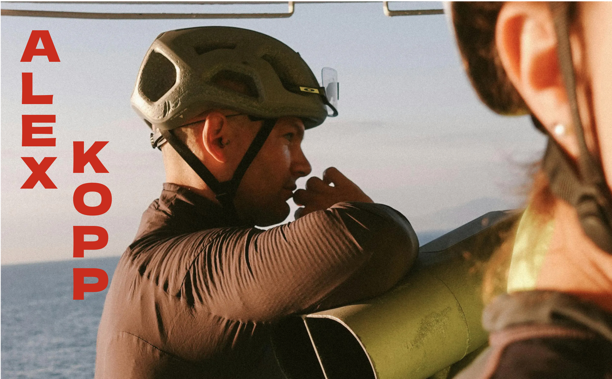 Alex Kopp in a helmet on a ferry deck, his name printed in red lettering