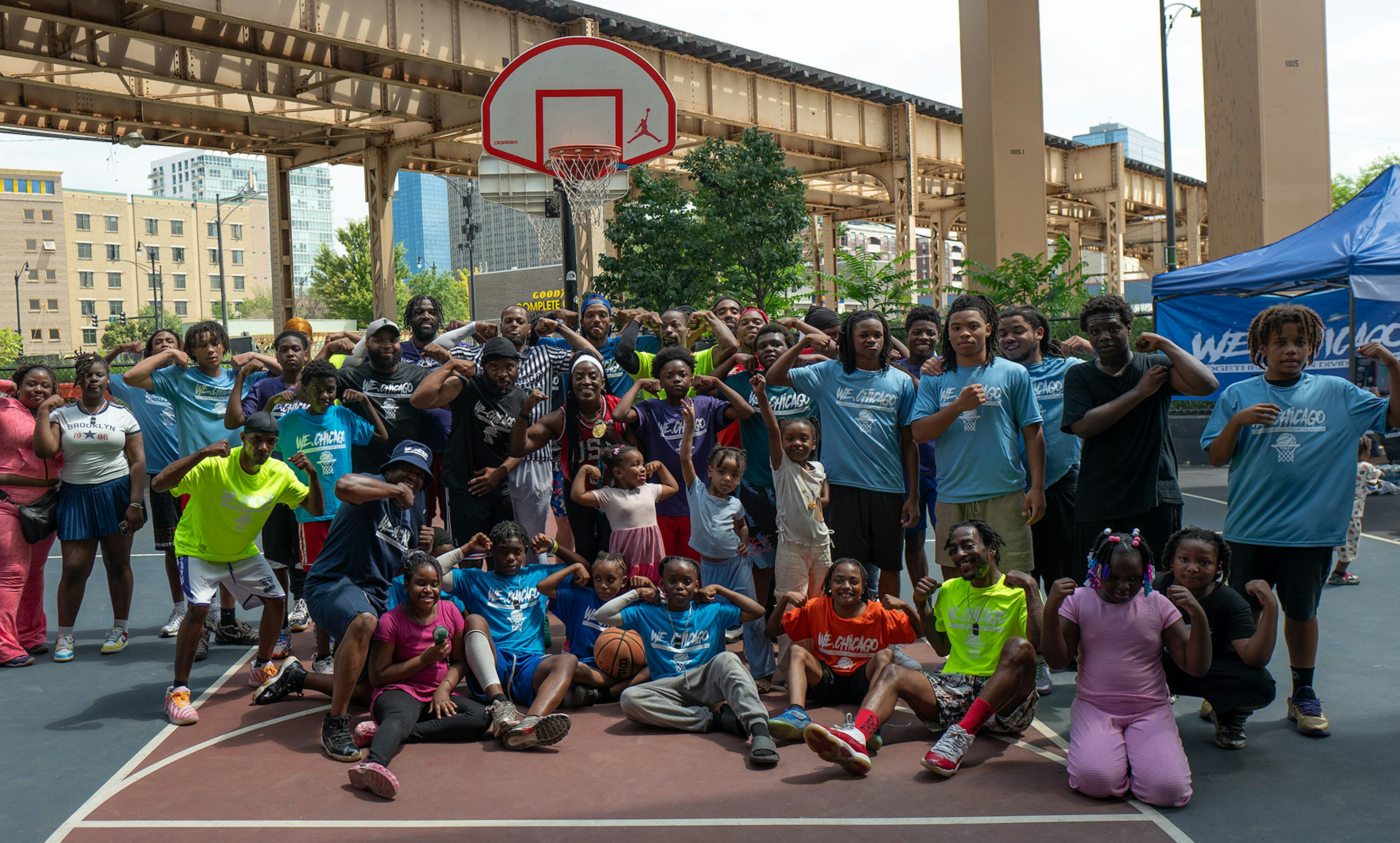 Ruthie Bolton stands with young athletes and community members on an outdoor basketball court