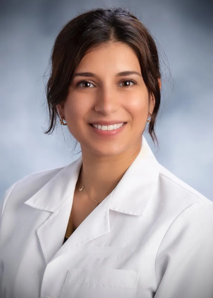 Dr. Dana Achmar smiling in a professional portrait