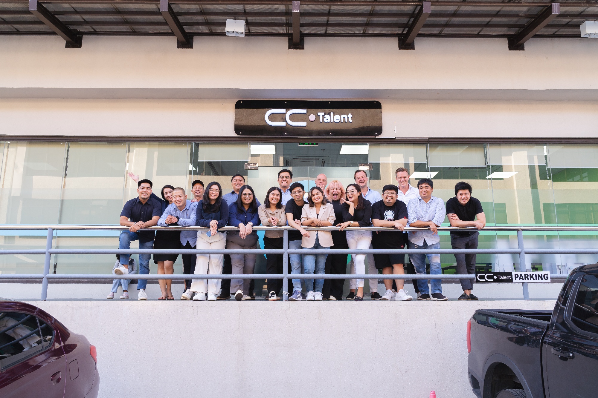 The CC.Talent Philippines team on the office balcony beneath the CC.Talent sign in Clark
