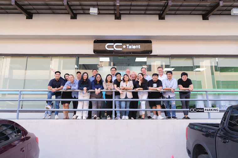 The CC.Talent Philippines team on the office balcony beneath the CC.Talent sign in Clark