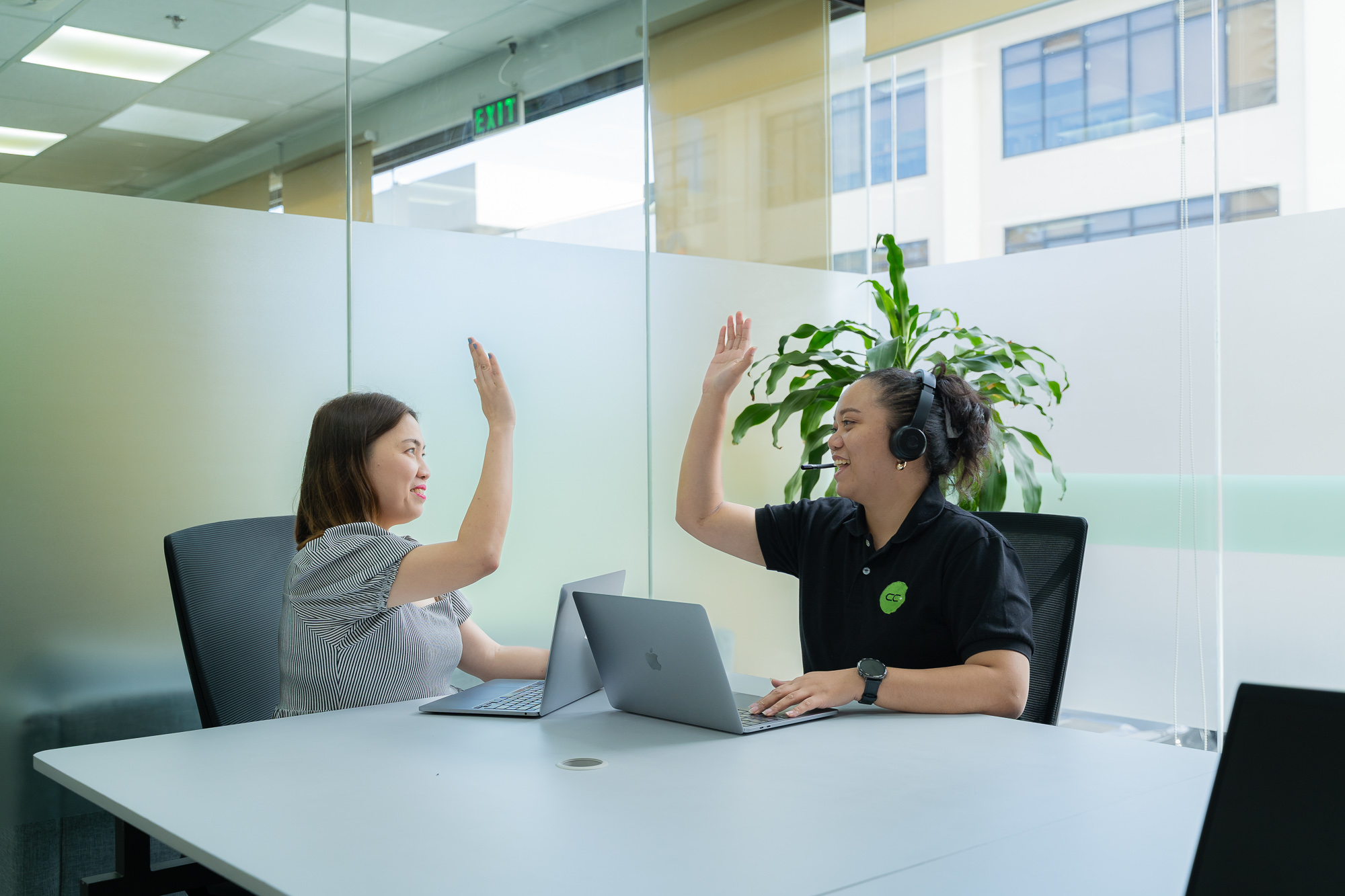 Two CC.Talent colleagues smiling as they close a deal together at the Manila office