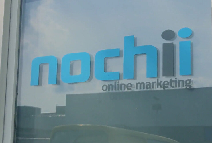 The Nochii Online Marketing logo mounted on the glass front of the agency's office