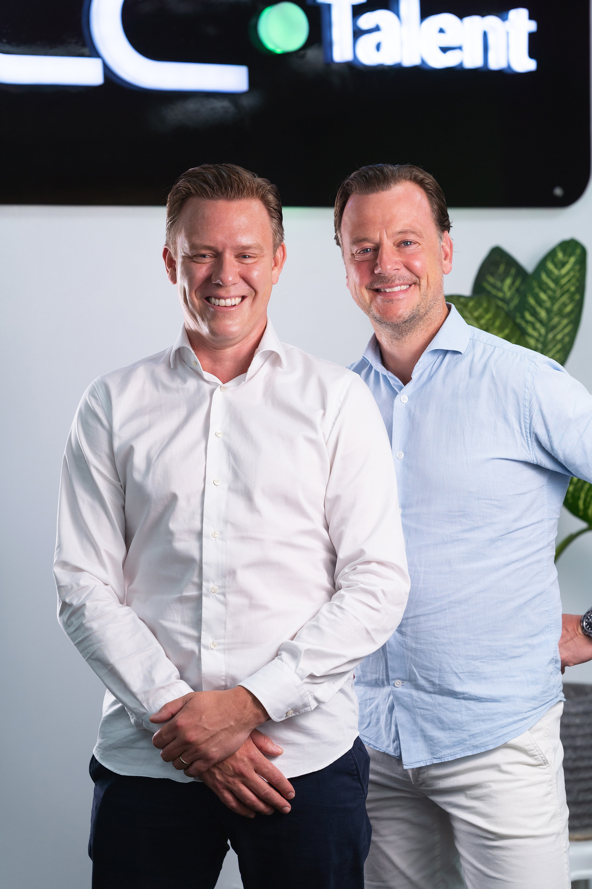 CC.Talent's two founders standing side by side in front of the CC.Talent sign