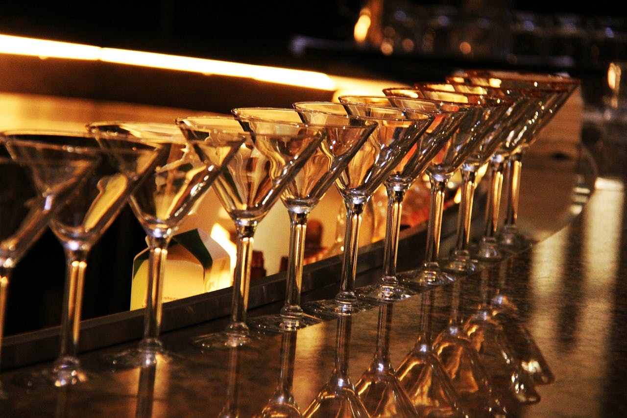 Glasses lined up in a dimly lit bar