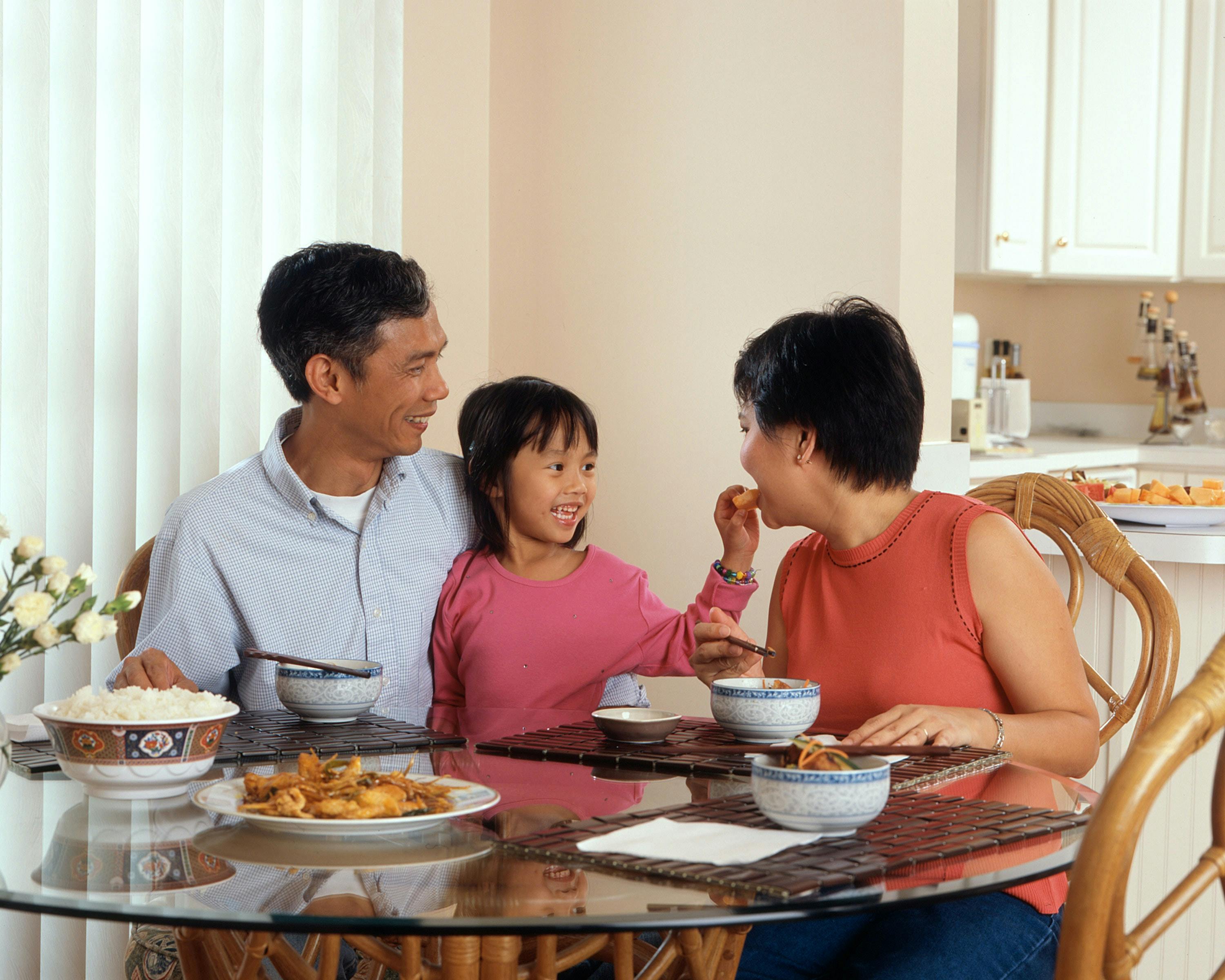 Happy Family eating a healthy meal which includes rice