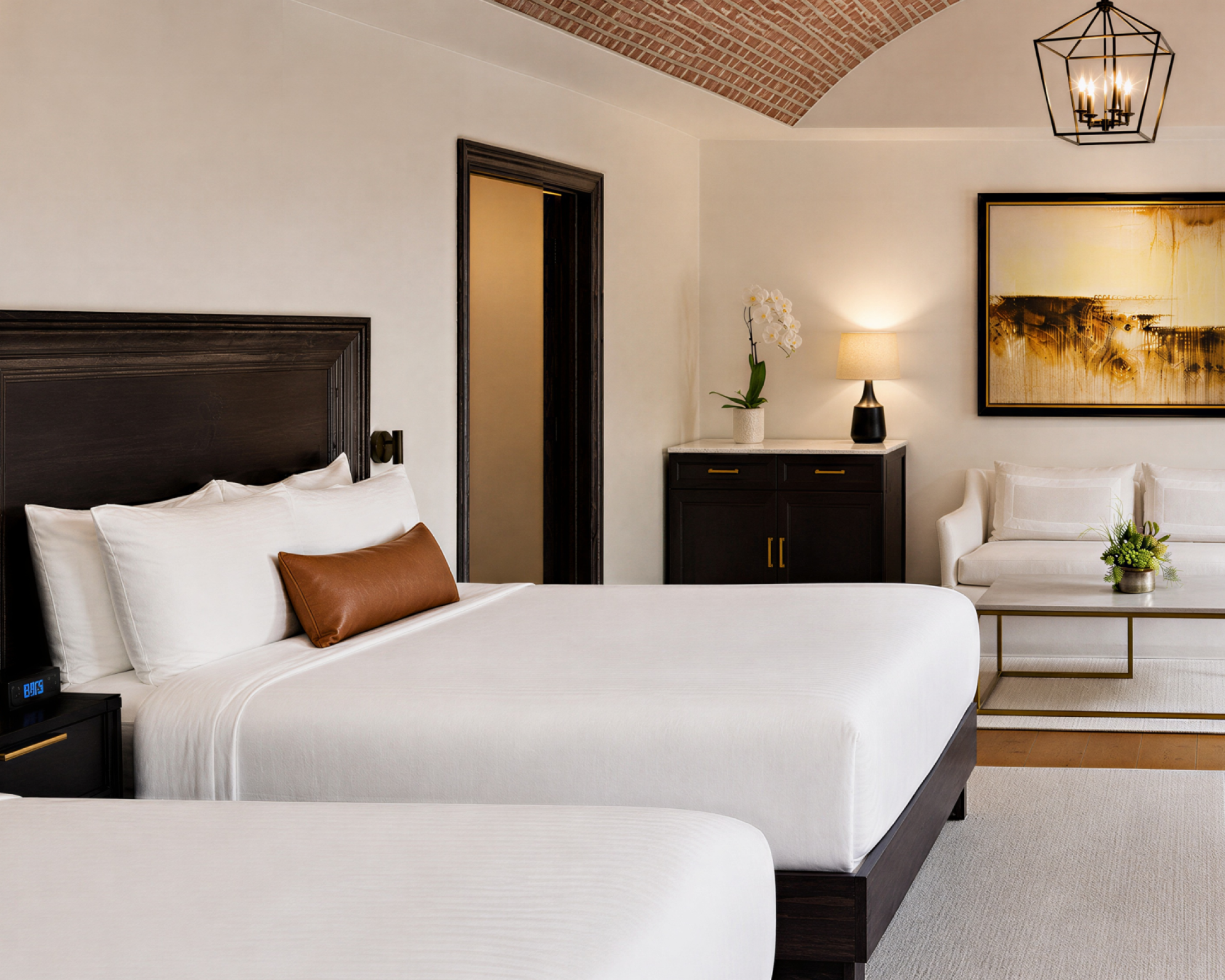 Hotel room with bed, seating area, and brick ceiling