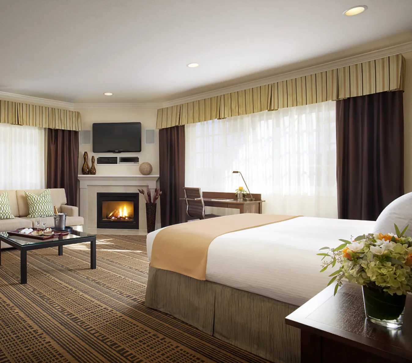 Hotel room with fireplace, king bed, and seating area