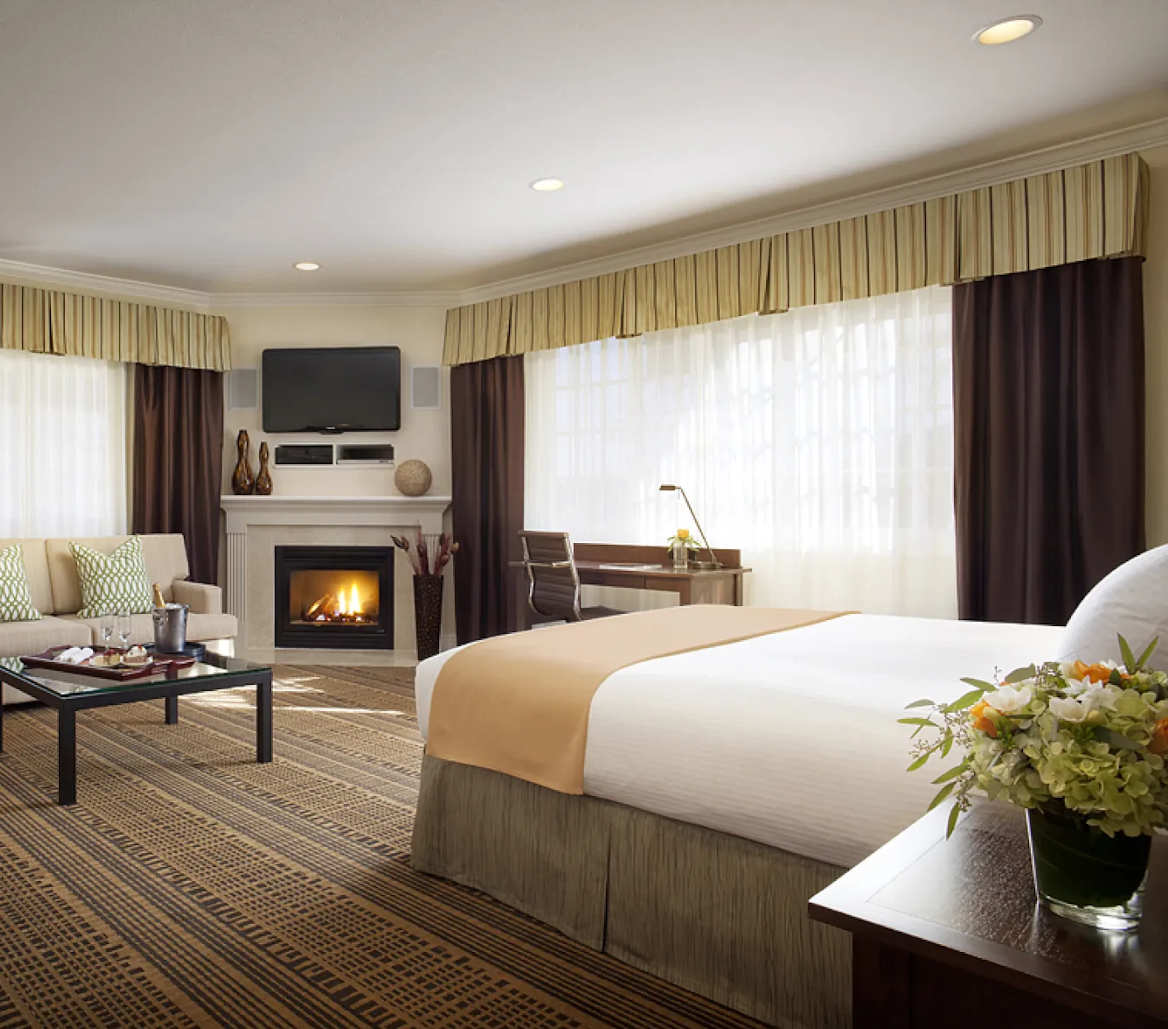 Hotel room with fireplace, king bed, and seating area