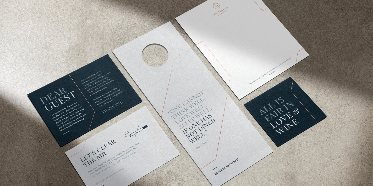 Flat lay perspective of different printed collateral for the Glen Clove Mansion including a door hanger, letterhead and coaster