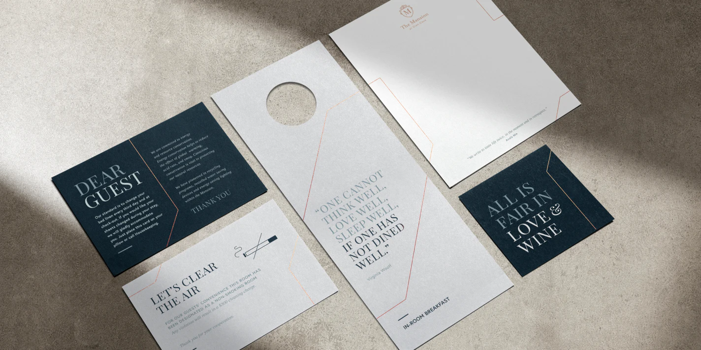 Flat lay perspective of different printed collateral for the Glen Clove Mansion including a door hanger, letterhead and coaster