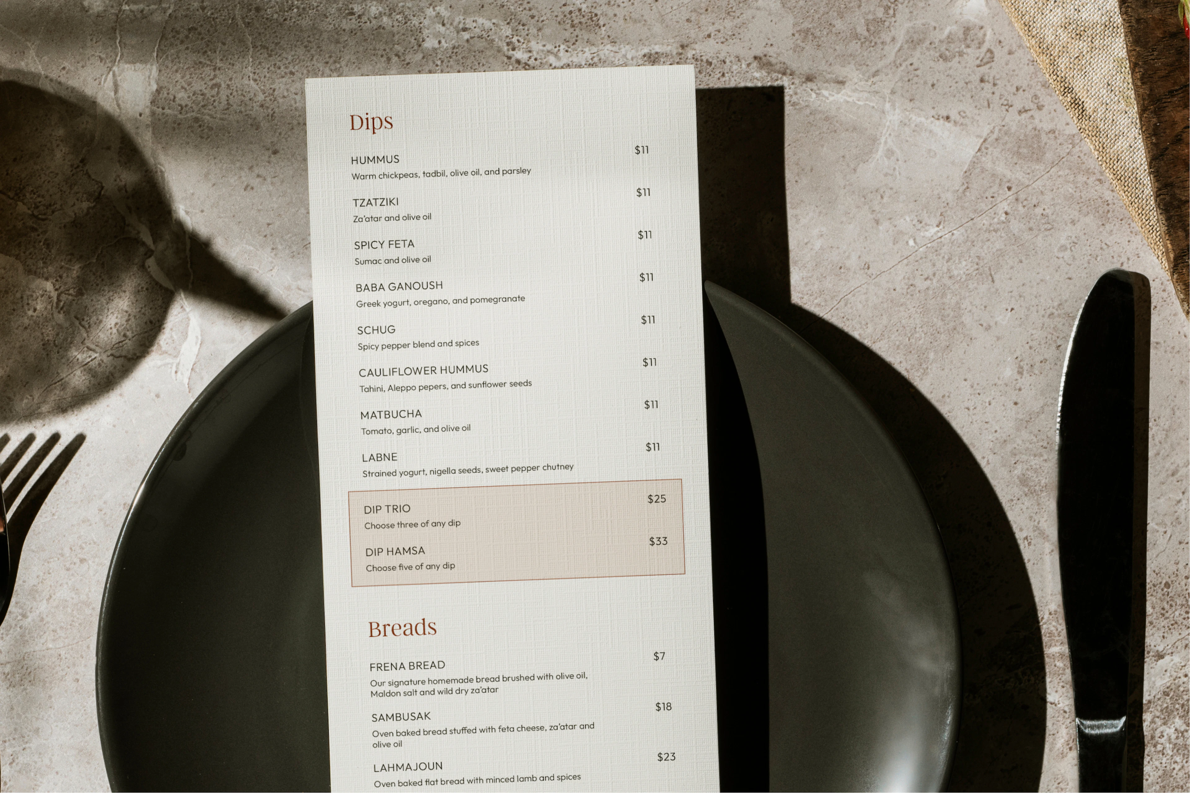 Frena dips menu on a table setting with black plates