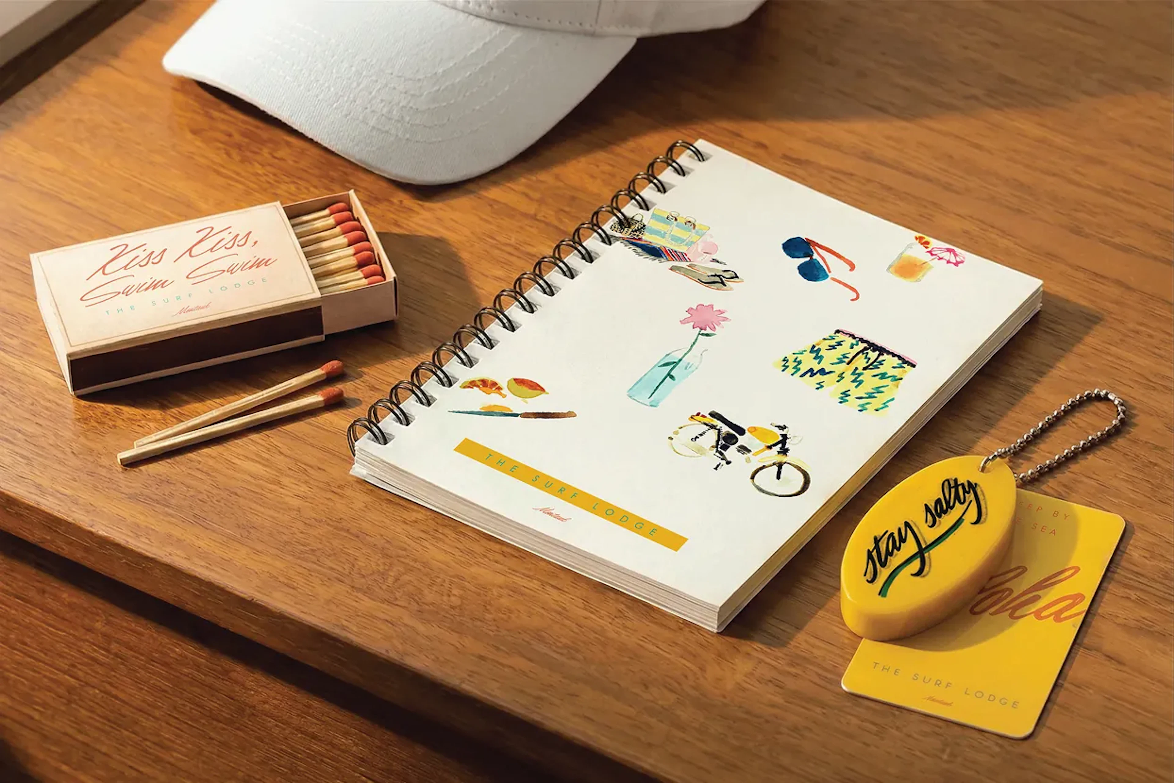 White cap, matchbox and notebook on a wooden desk