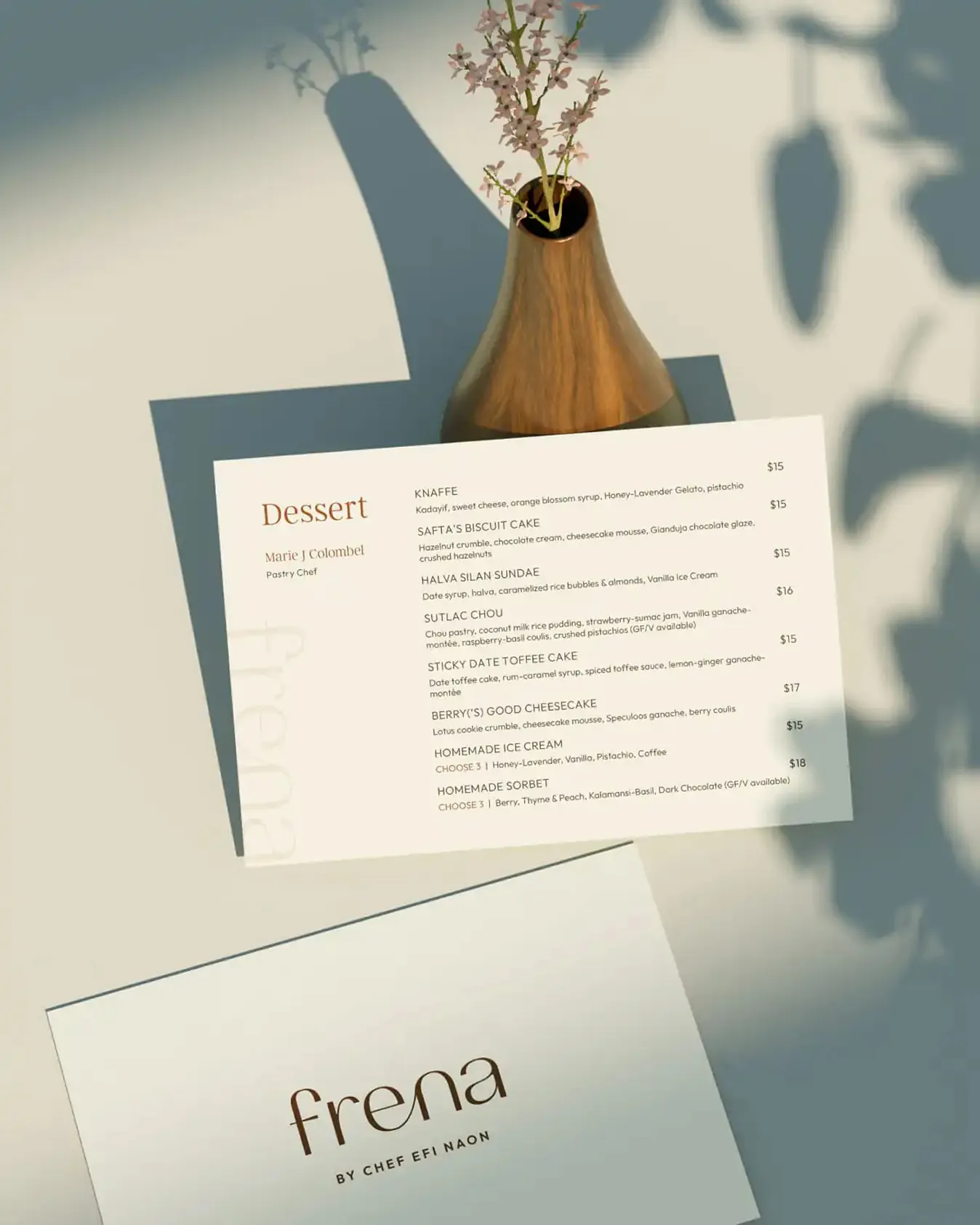 Frena dessert menu beside a small vase of flowers
