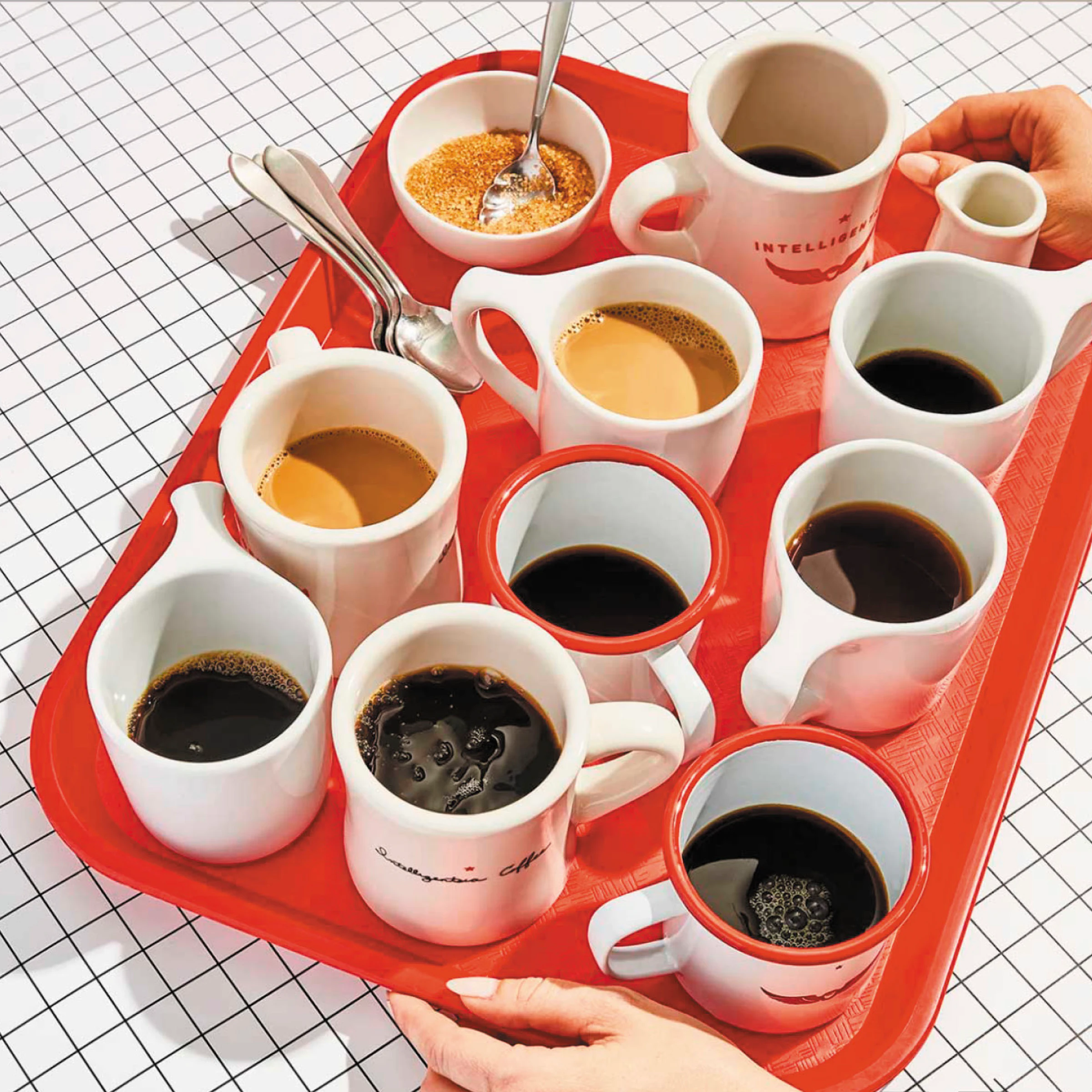 Tray of assorted coffee cups with hands reaching in