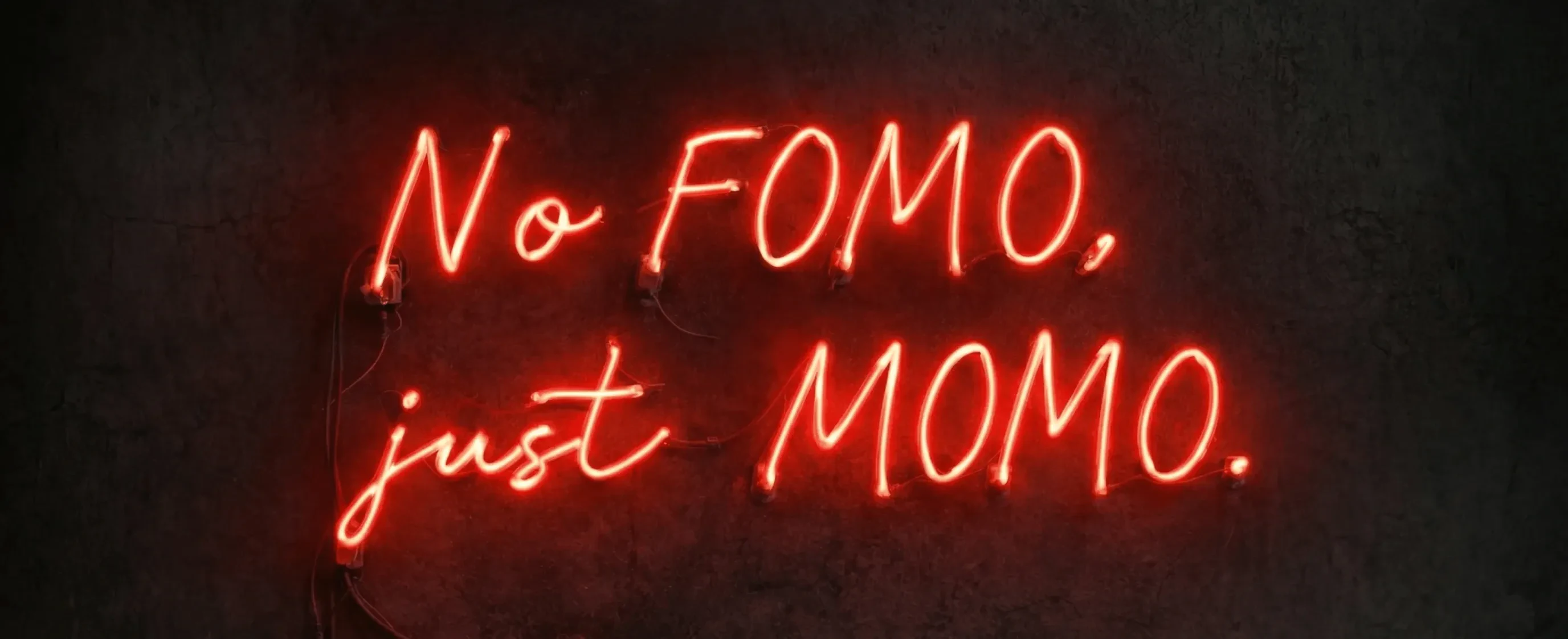 neon lights that say "No FOMO, just MOMO."