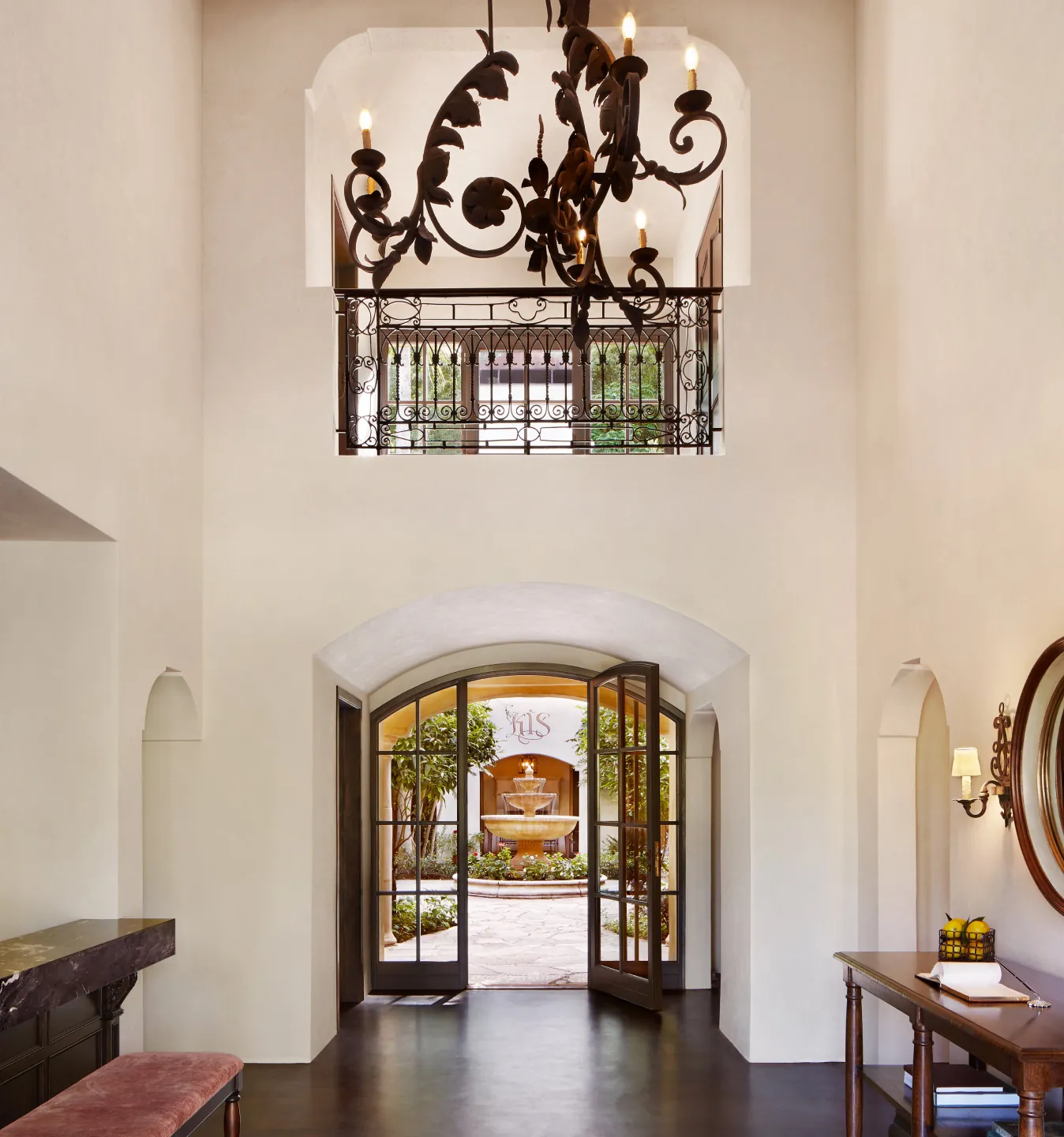 Wrought iron chandelier above an arched entryway
