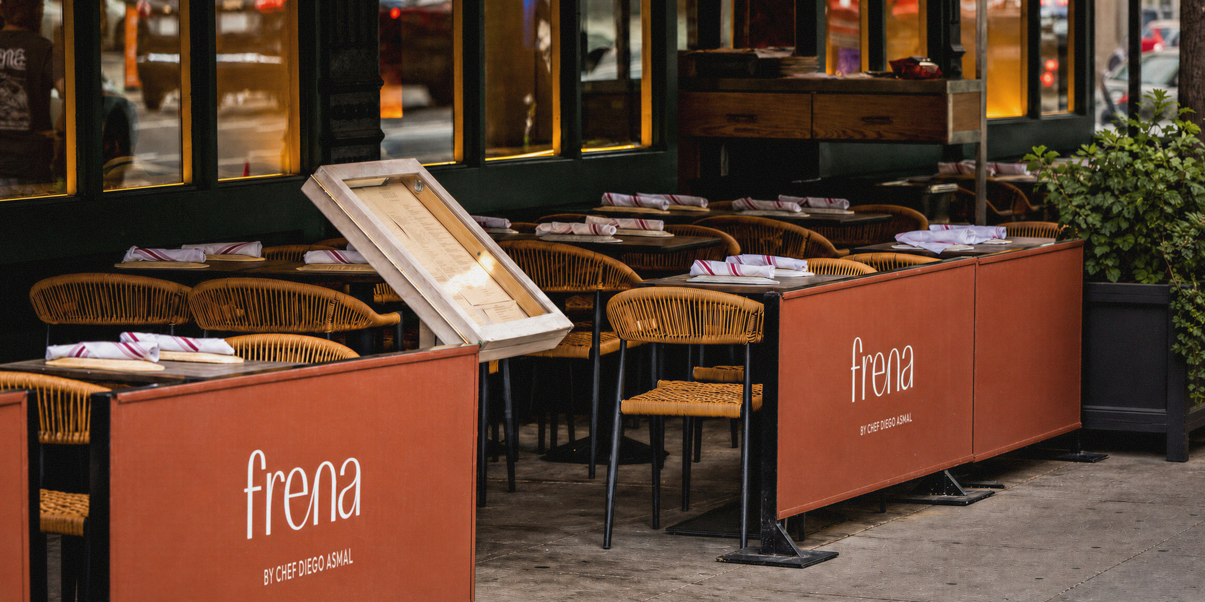 Frena sidewalk cafe seating with orange banners and rattan chairs