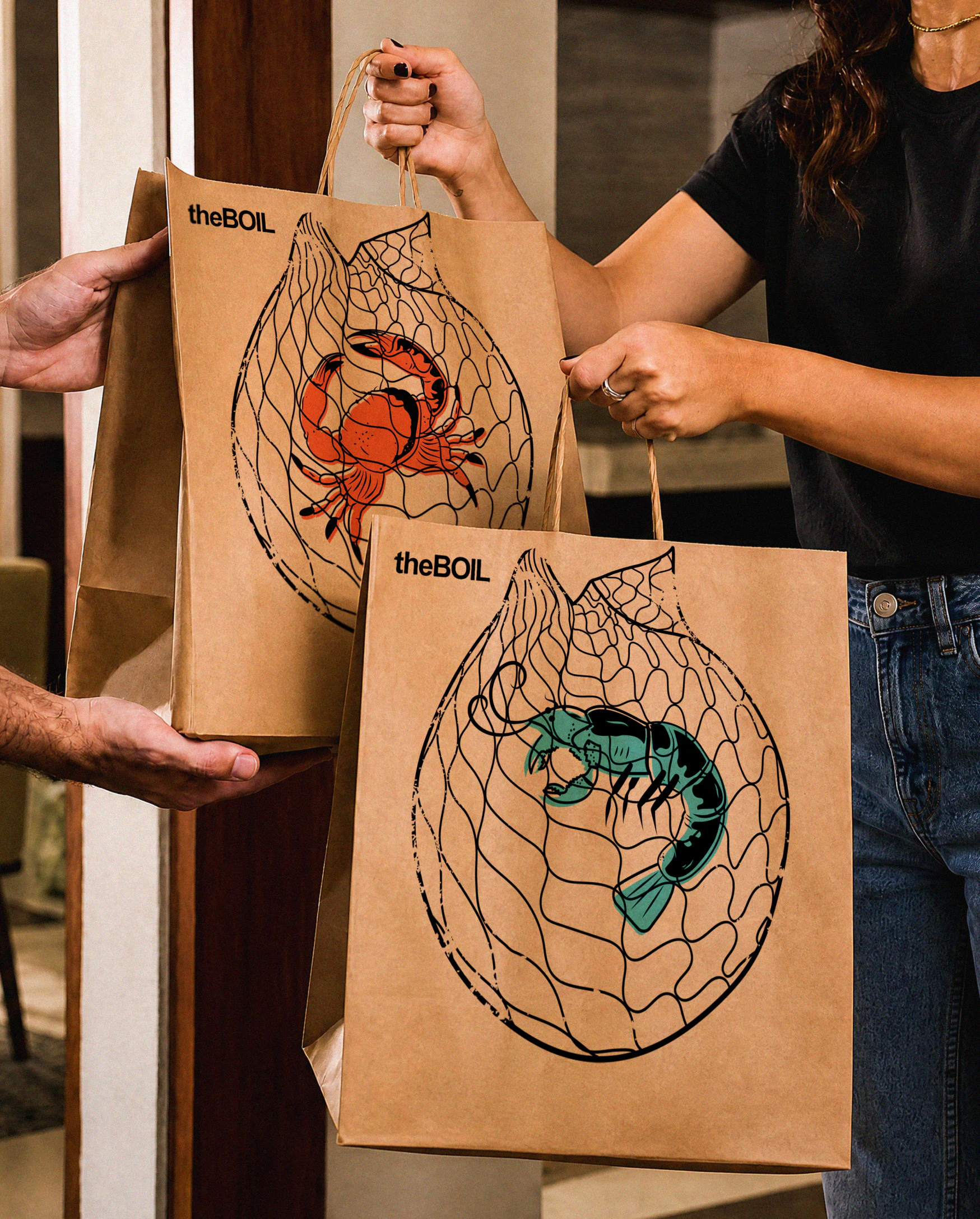 Woman taking 2 brown paper takeout bags from a delivery person, the front of the bags have the boil logo and crab and shrimp tattoo style illustrations