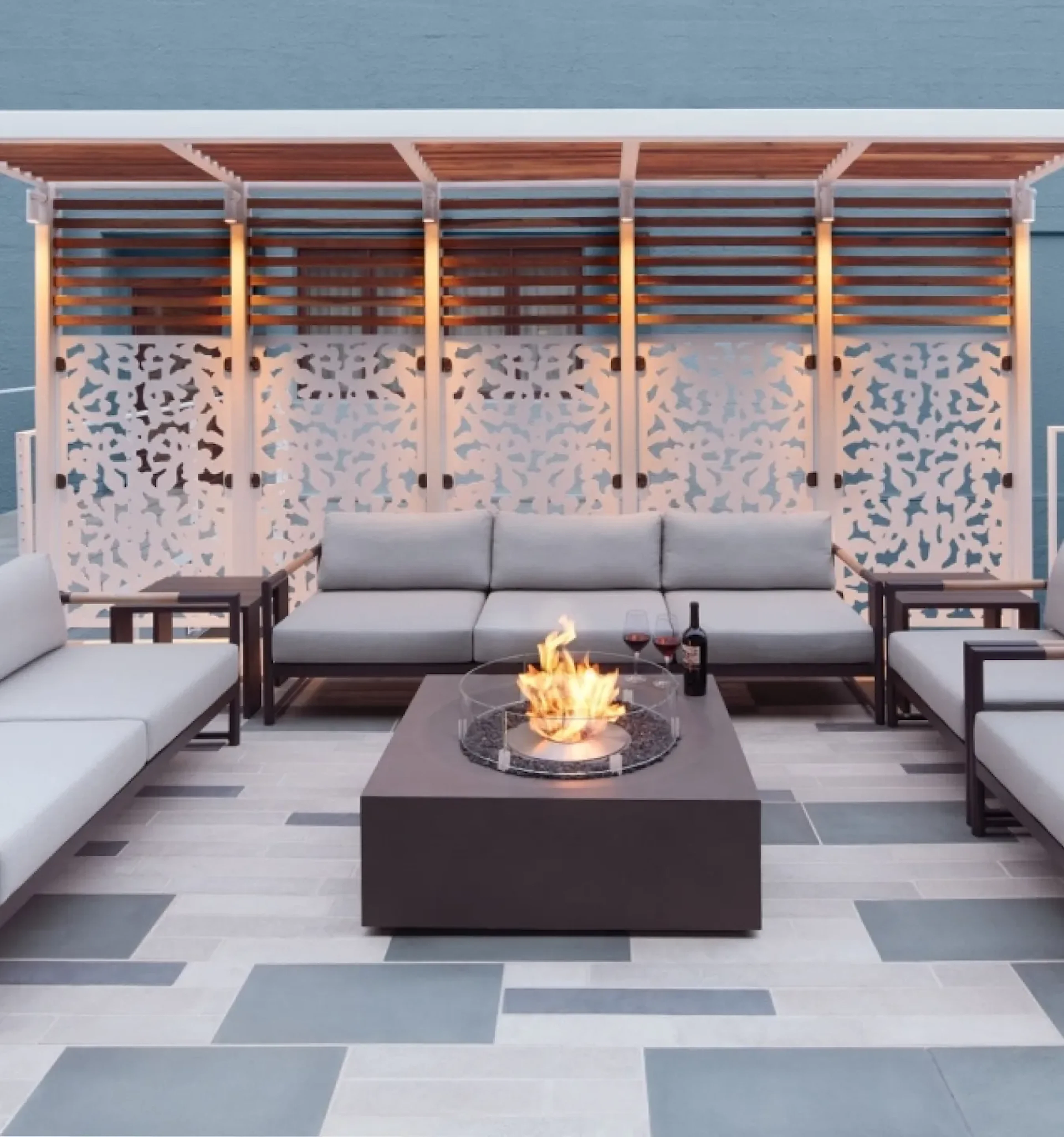 Outdoor lounge with fire pit table under wood pergola