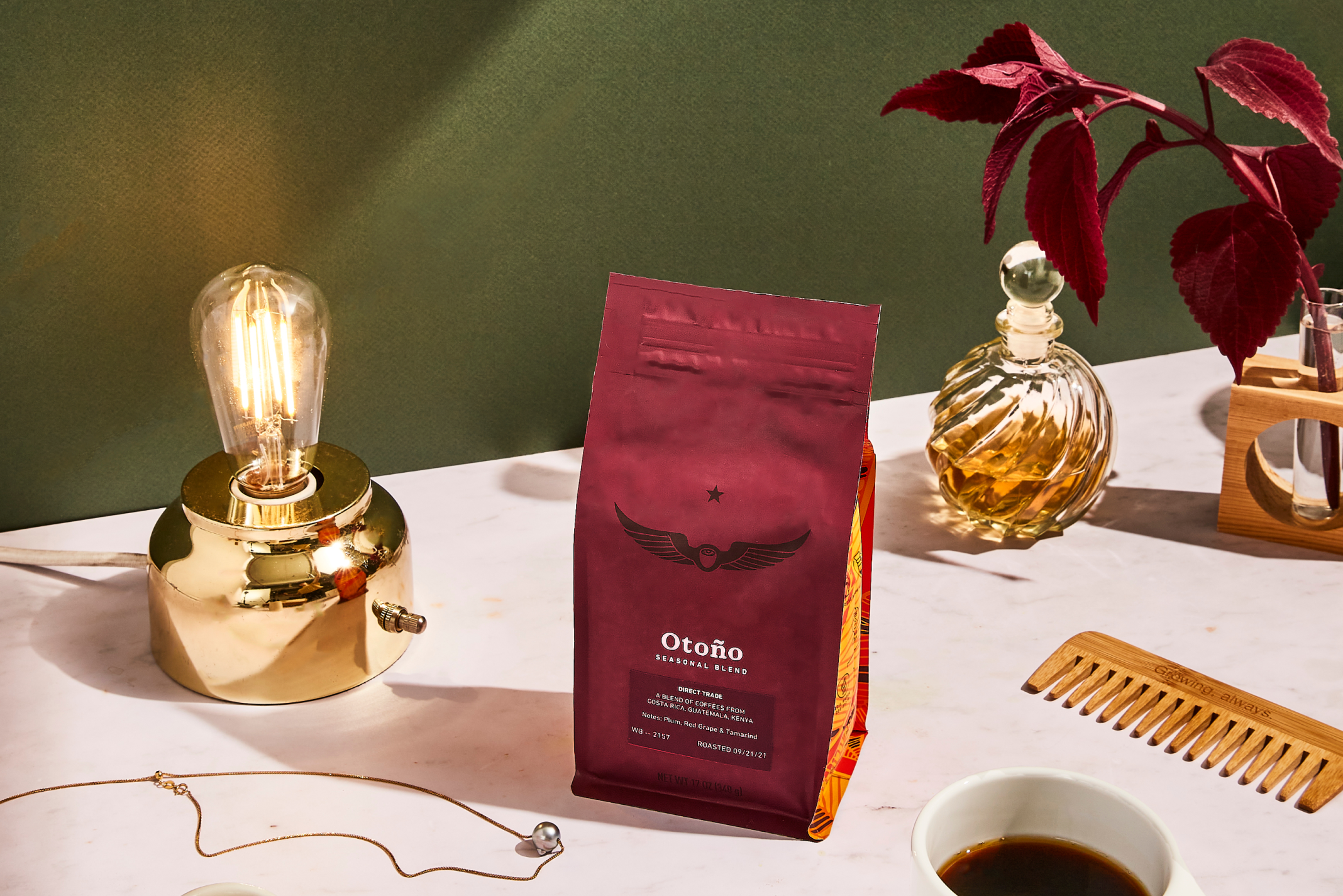 Bag of Otoño coffee beans on a table with a lamp and jewelry
