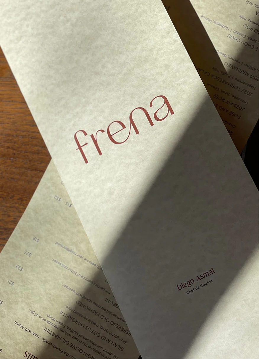 Frena menu cover with chef names on overlapping pages
