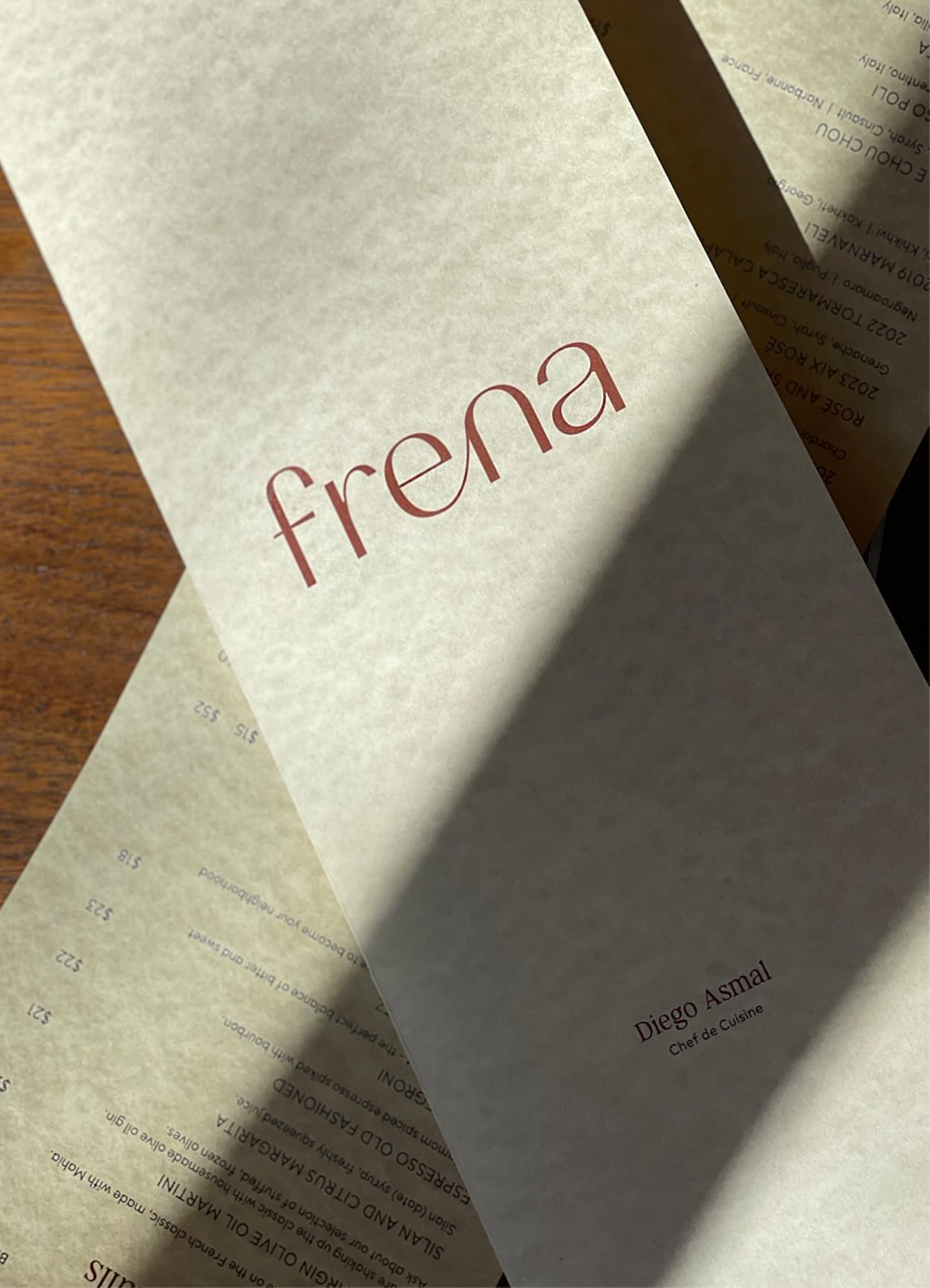 Frena menu cover with chef names on overlapping pages