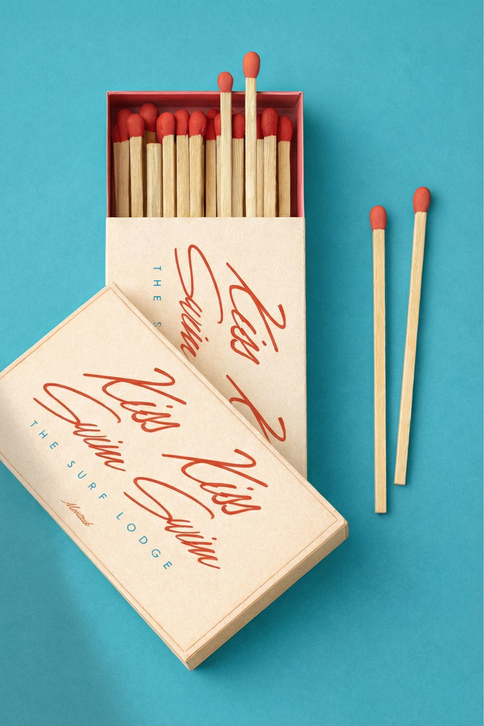 Open matchbox branded The Surf Lodge on teal background