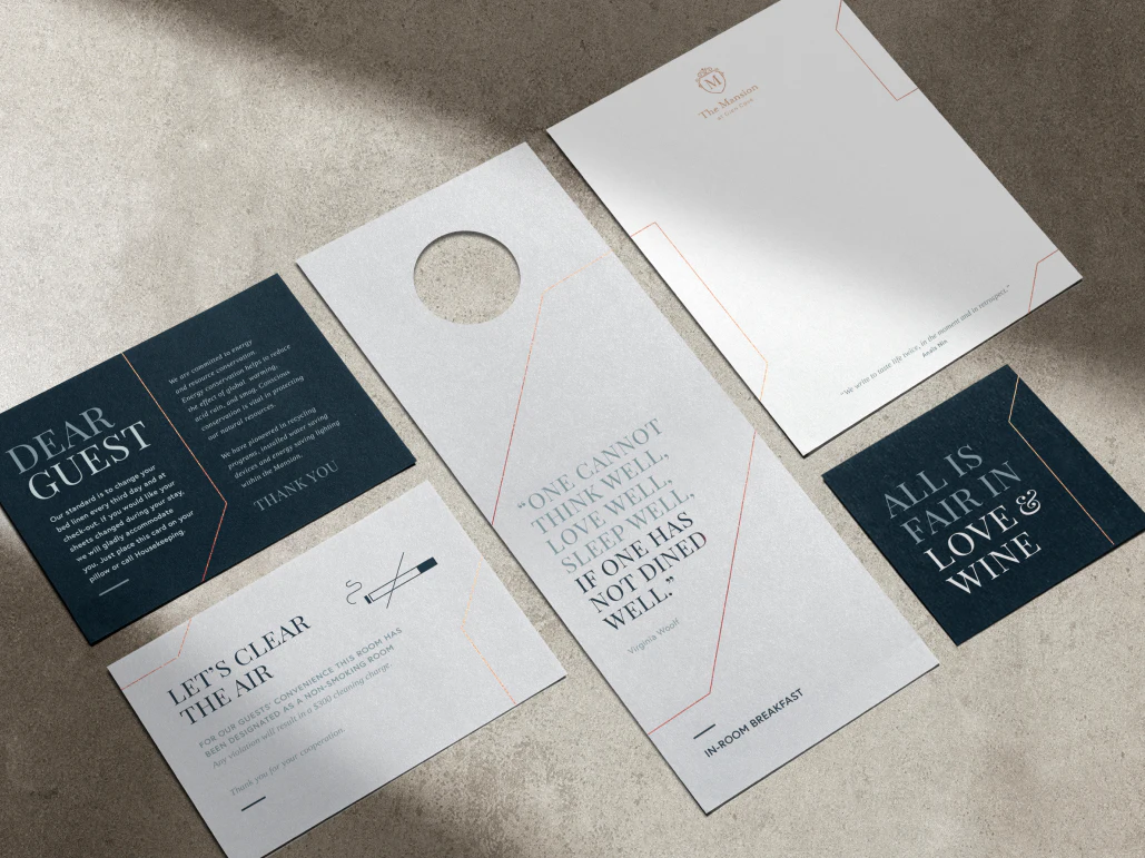 Flat lay perspective of different printed collateral for the Glen Clove Mansion including a door hanger, letterhead and coaster