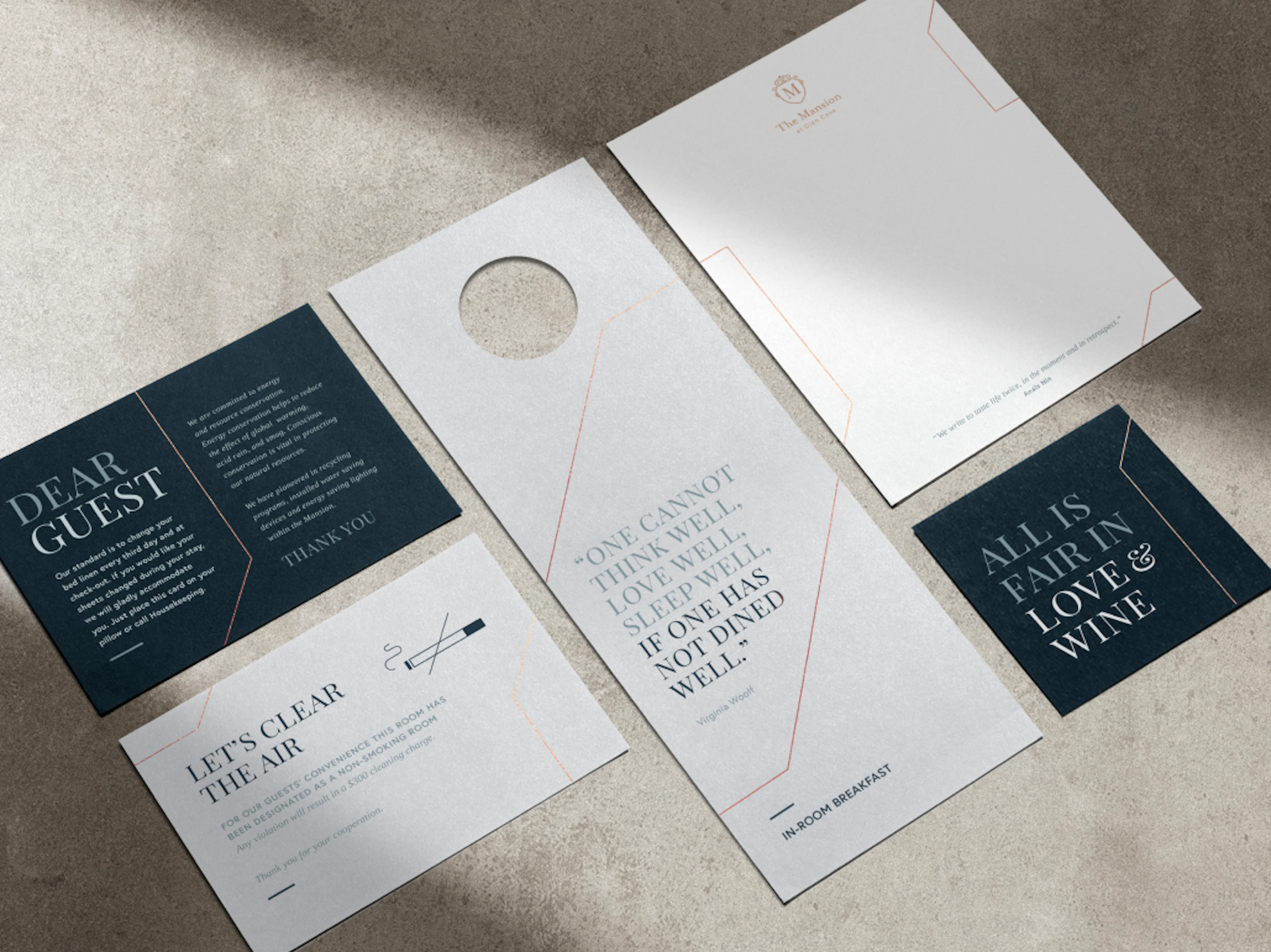 Flat lay perspective of different printed collateral for the Glen Clove Mansion including a door hanger, letterhead and coaster