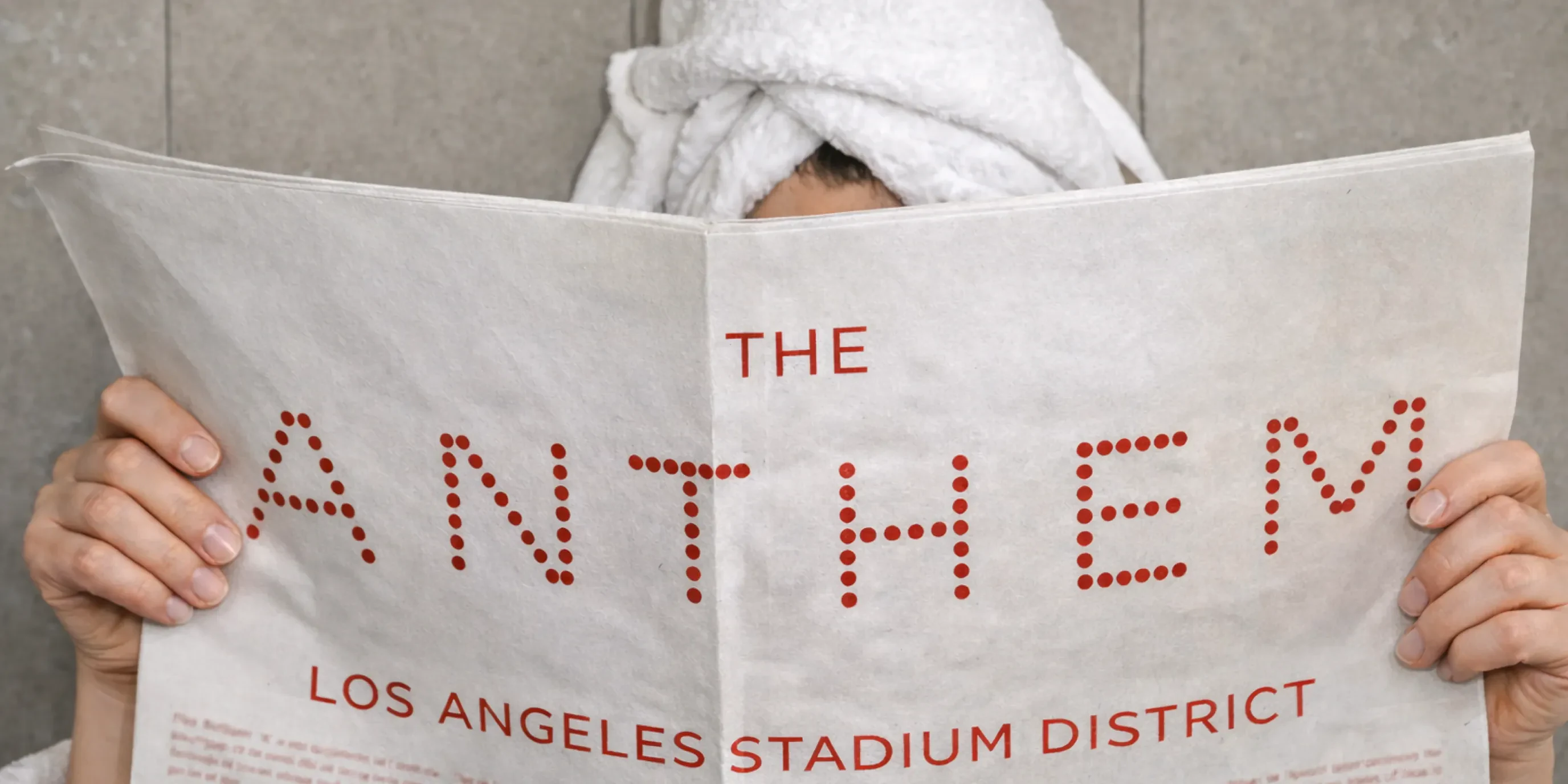 Person in towel headwrap reading Anthem newspaper mockup