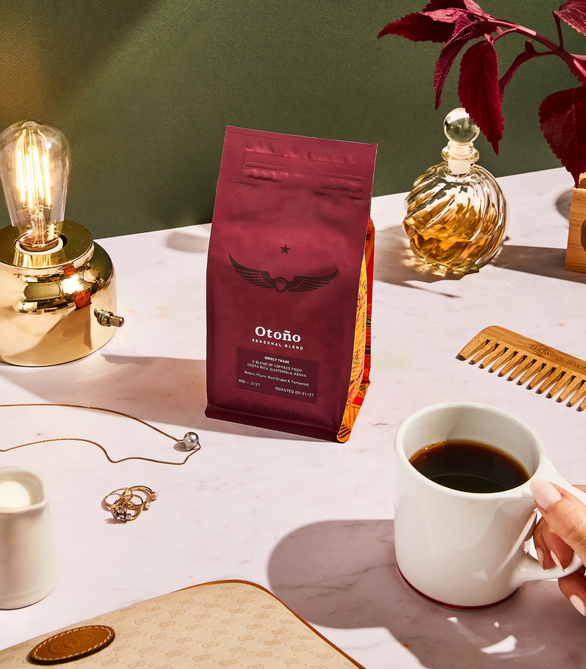 Bag of Otoño coffee beans on a table with a lamp and jewelry