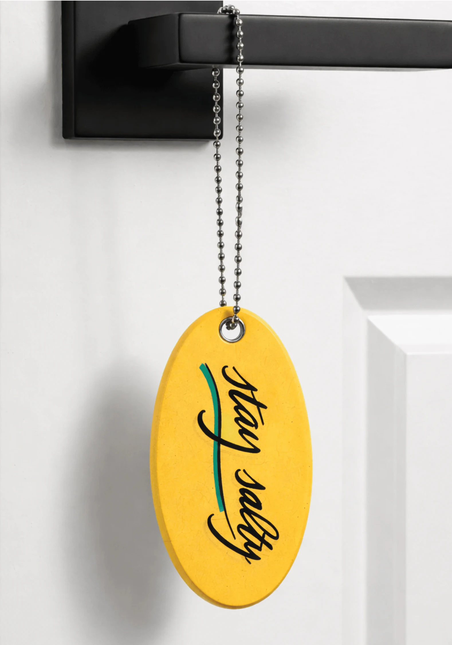 Surf Lodge yellow key chain float hanging on a door handle as a welcome gift.