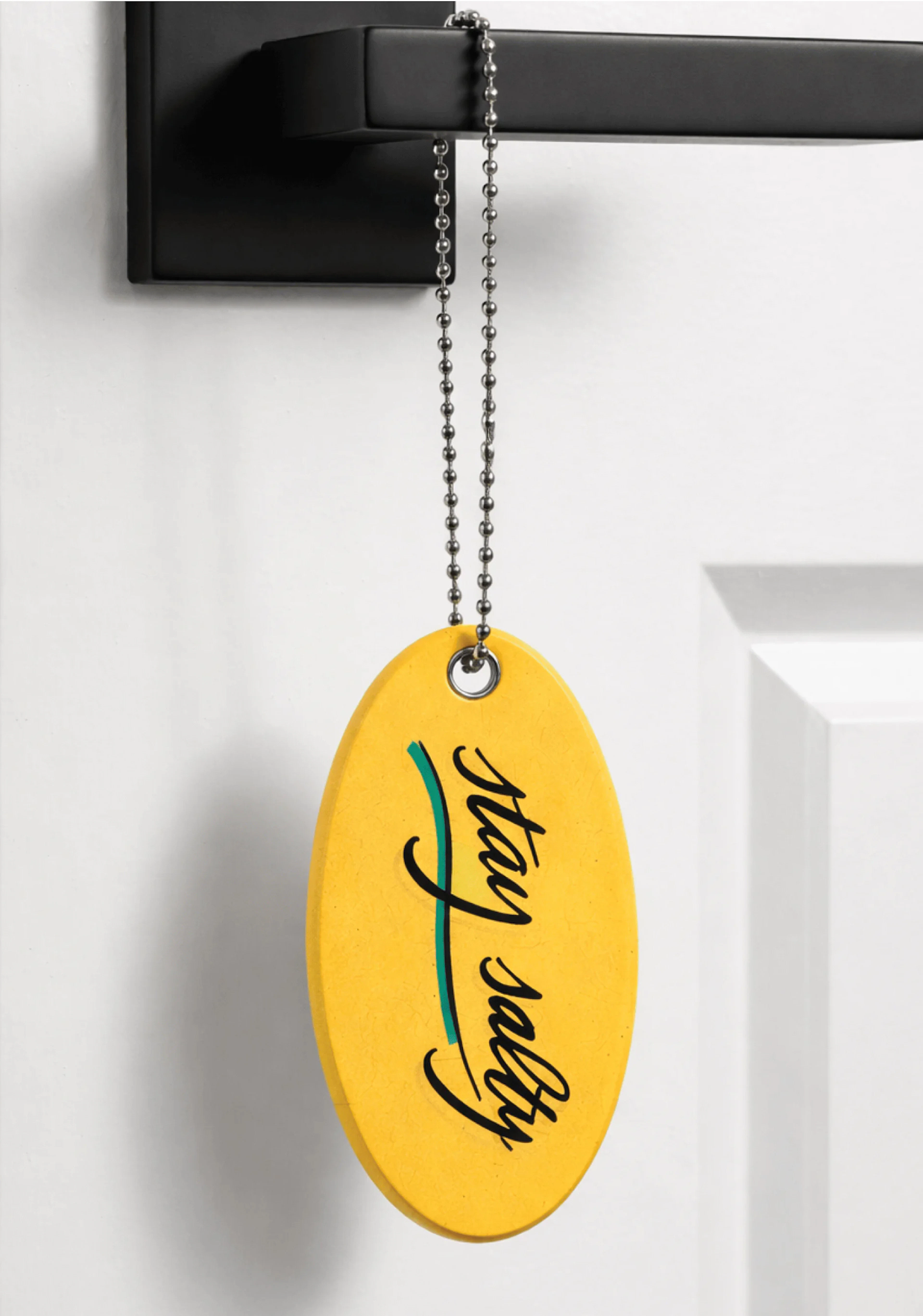 Surf Lodge yellow key chain float hanging on a door handle as a welcome gift.