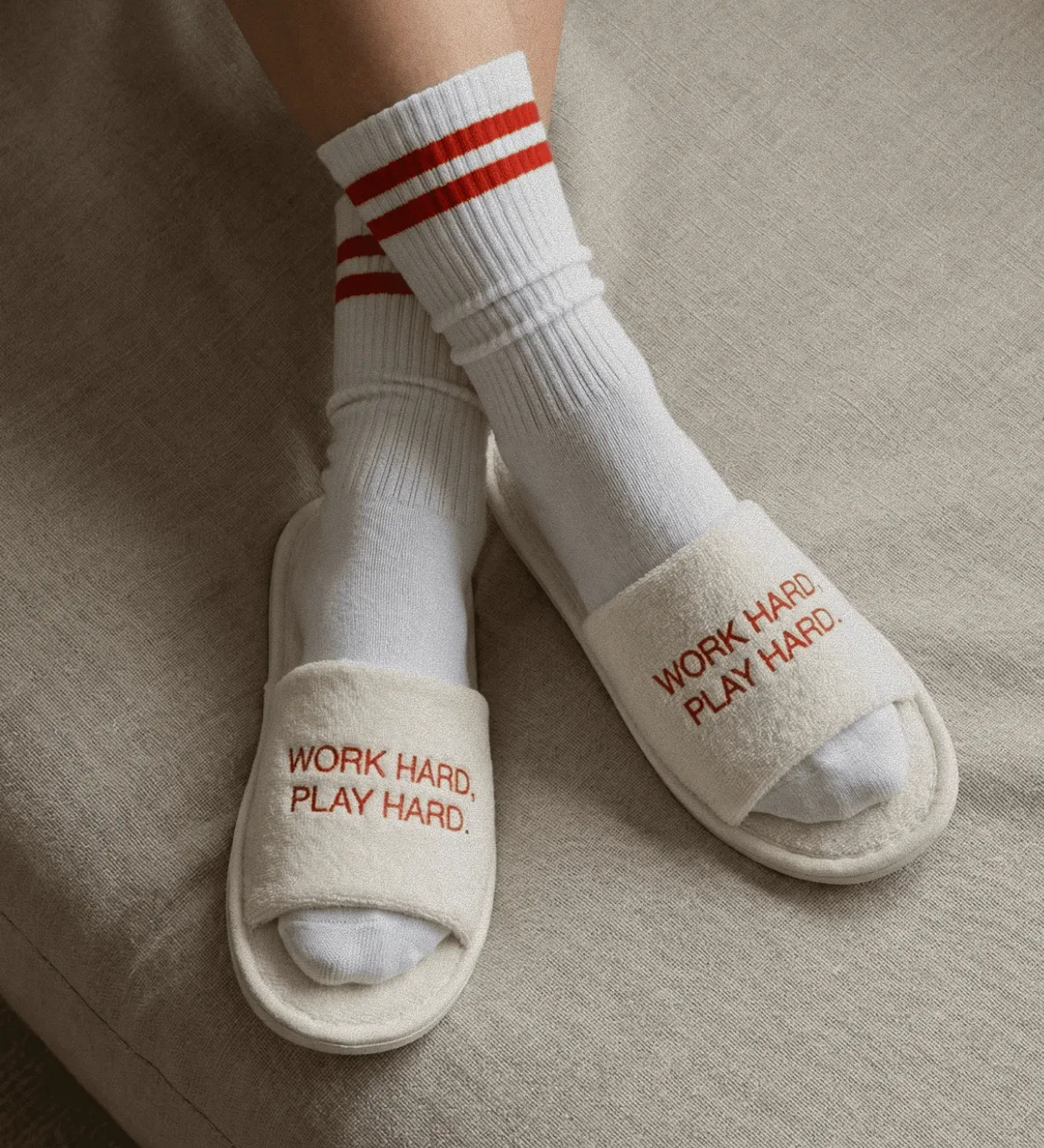 Image of branded slippers that say "Work Hard Play Hard".