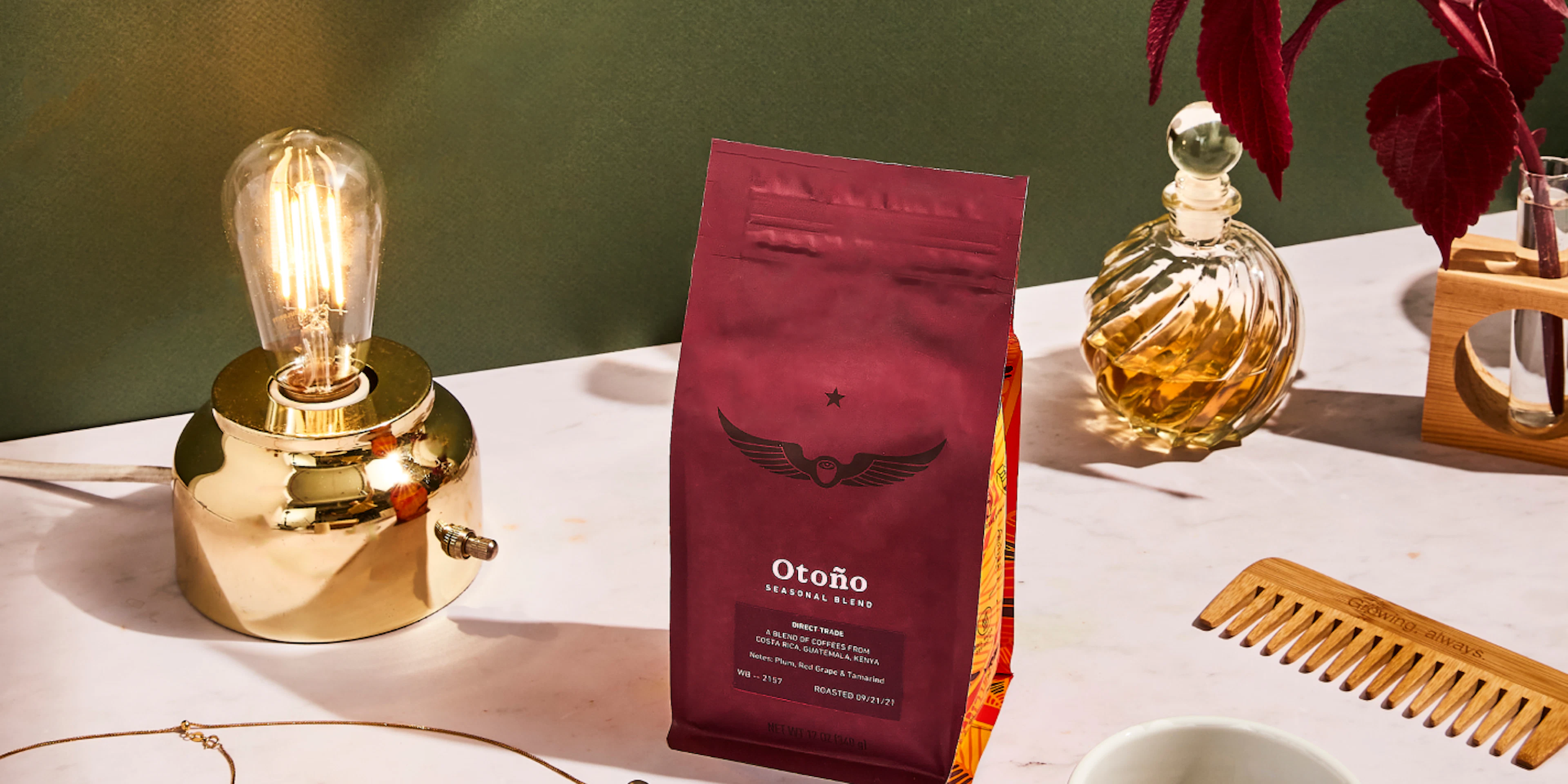 Bag of Otoño coffee beans on a table with a lamp and jewelry