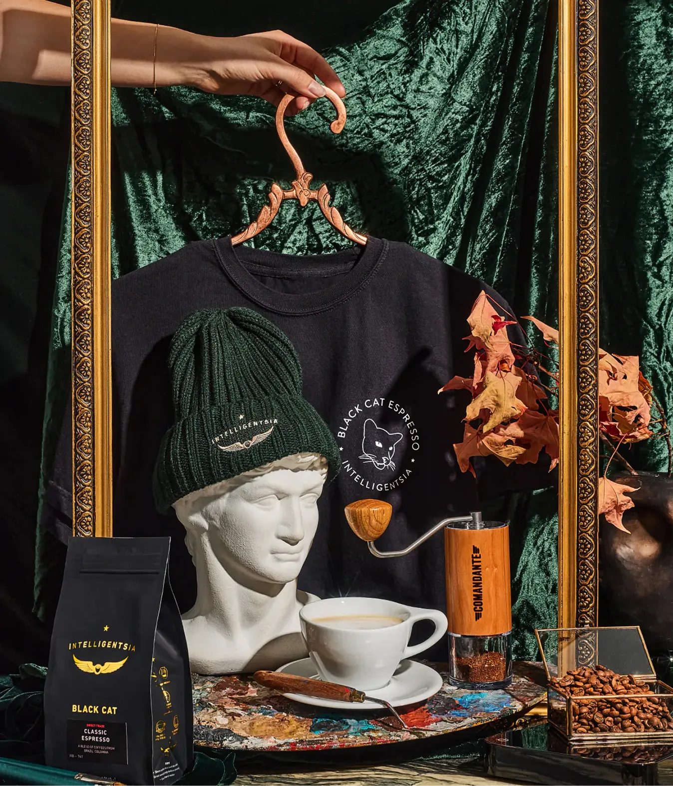 Black Cat Espresso sweatshirt, beanie and coffee bag on a green backdrop