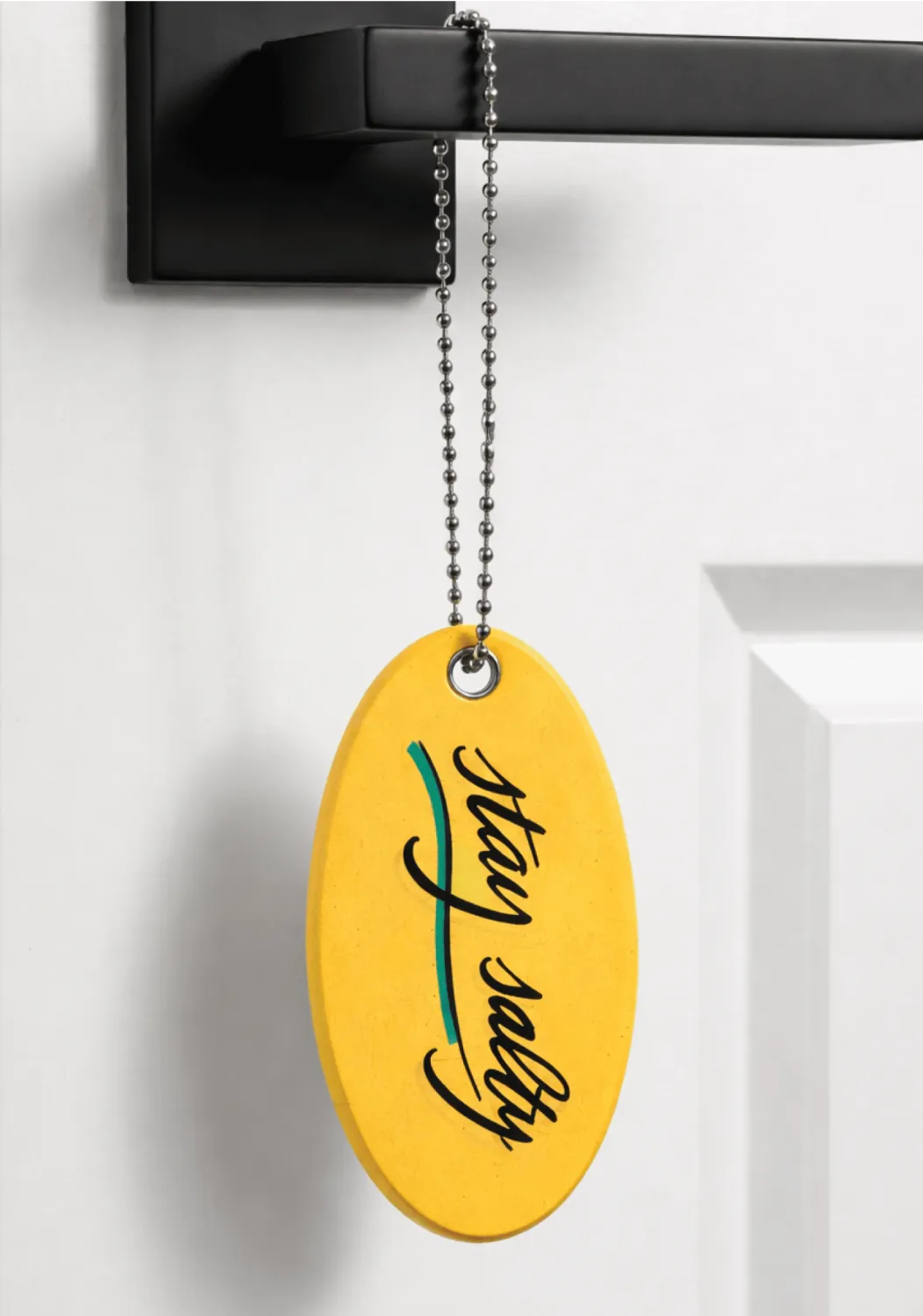 Surf Lodge yellow key chain float hanging on a door handle as a welcome gift.