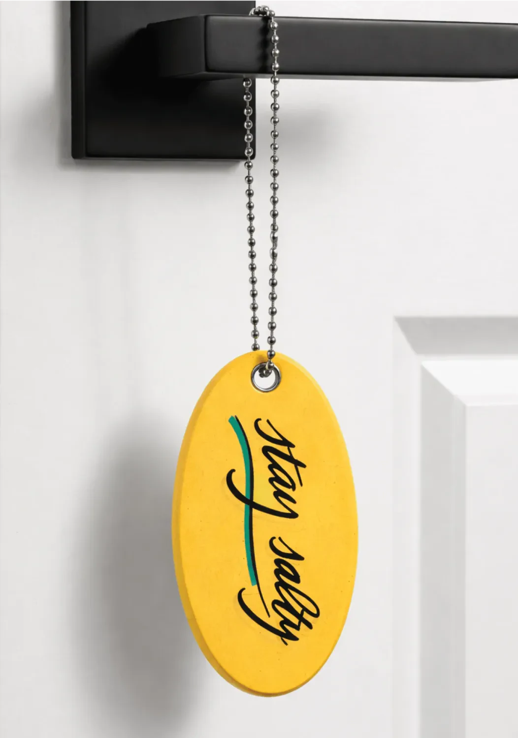 Surf Lodge yellow key chain float hanging on a door handle as a welcome gift.