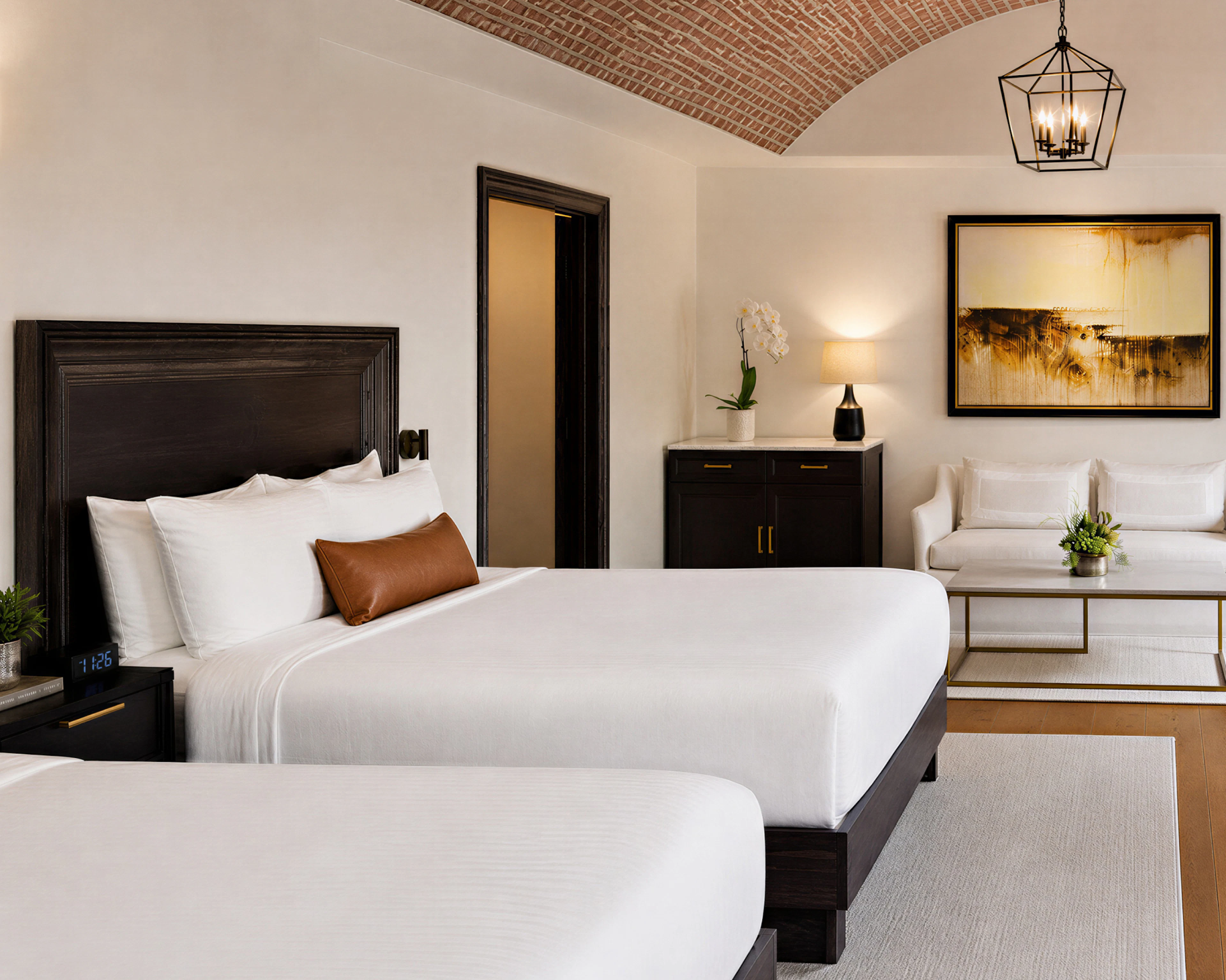 Hotel room with bed, seating area, and brick ceiling