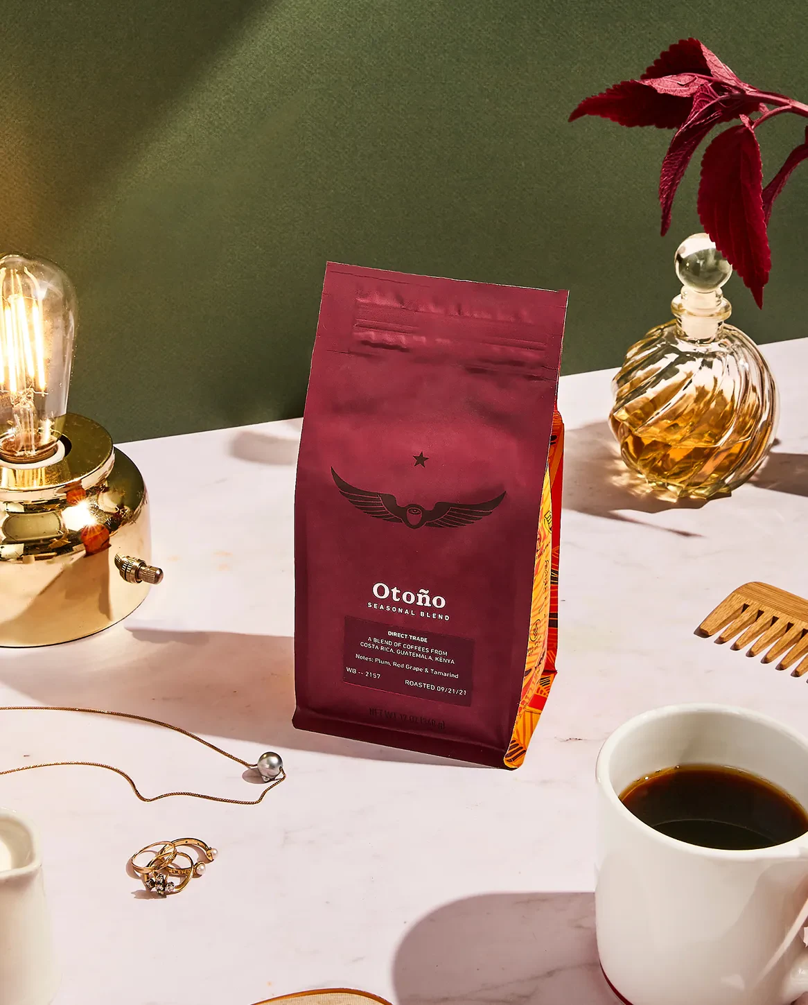 Bag of Otoño coffee beans on a table with a lamp and jewelry