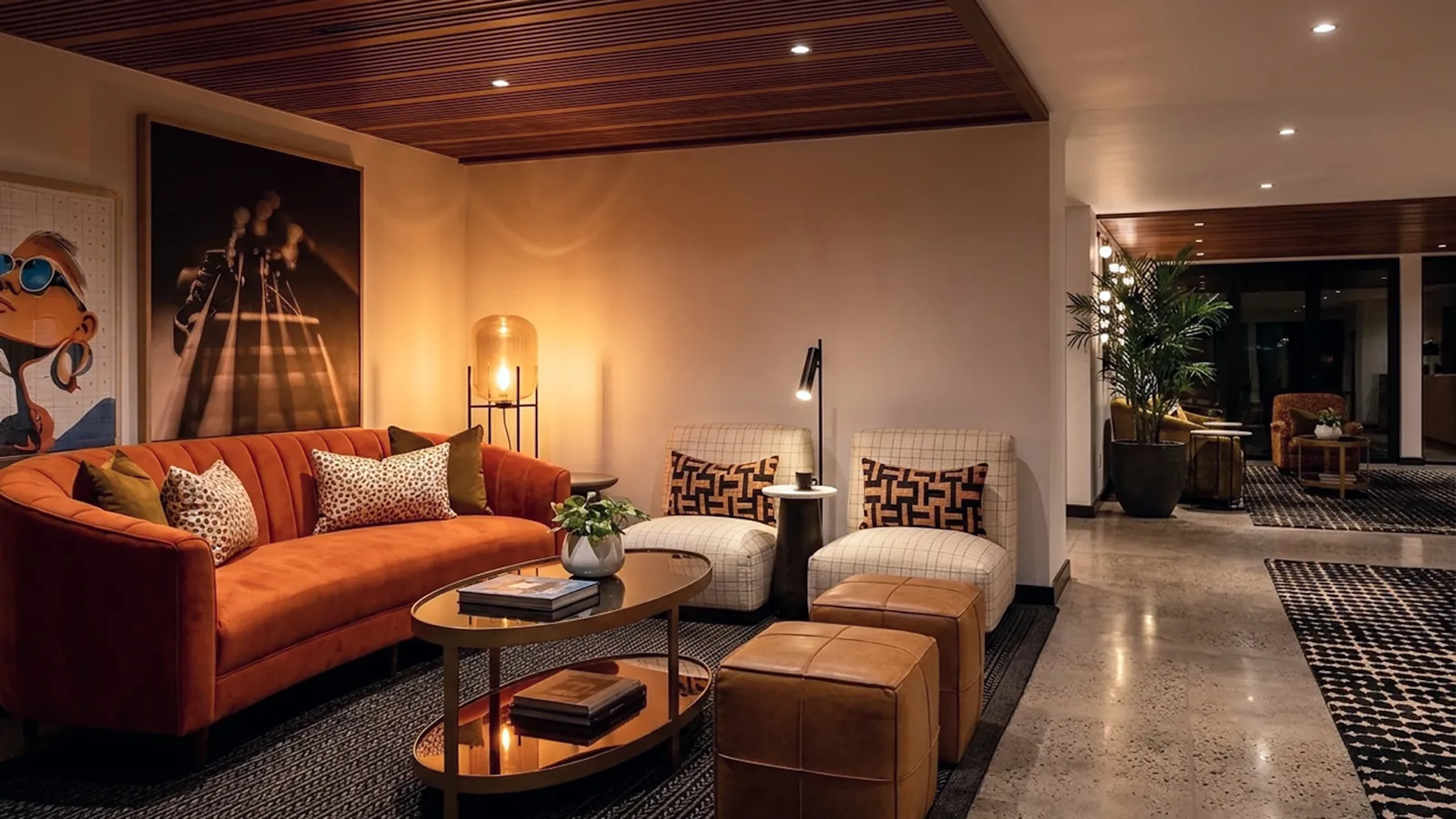 Lounge with orange curved sofa, patterned armchairs and framed artwork