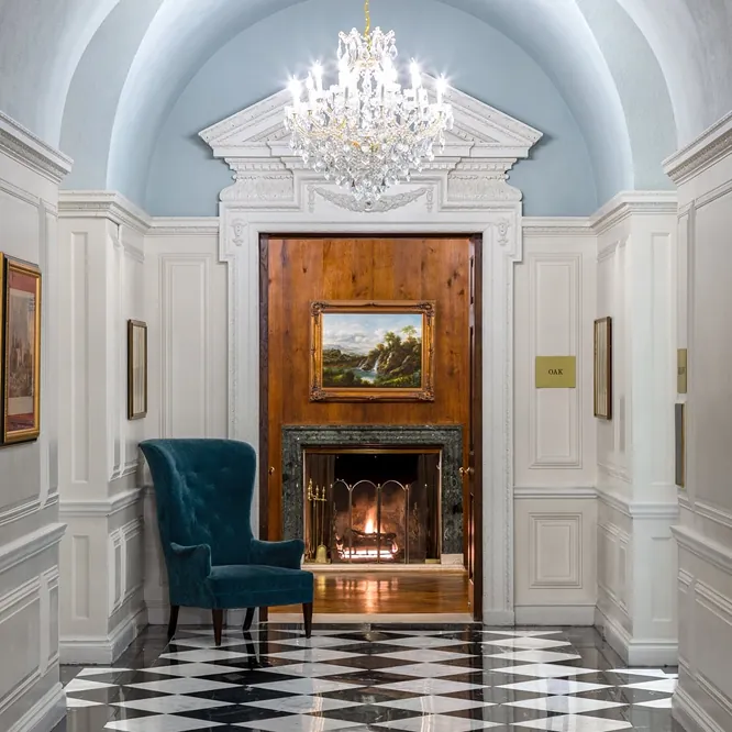 Blue armchair beside a fireplace in a sky blue alcove