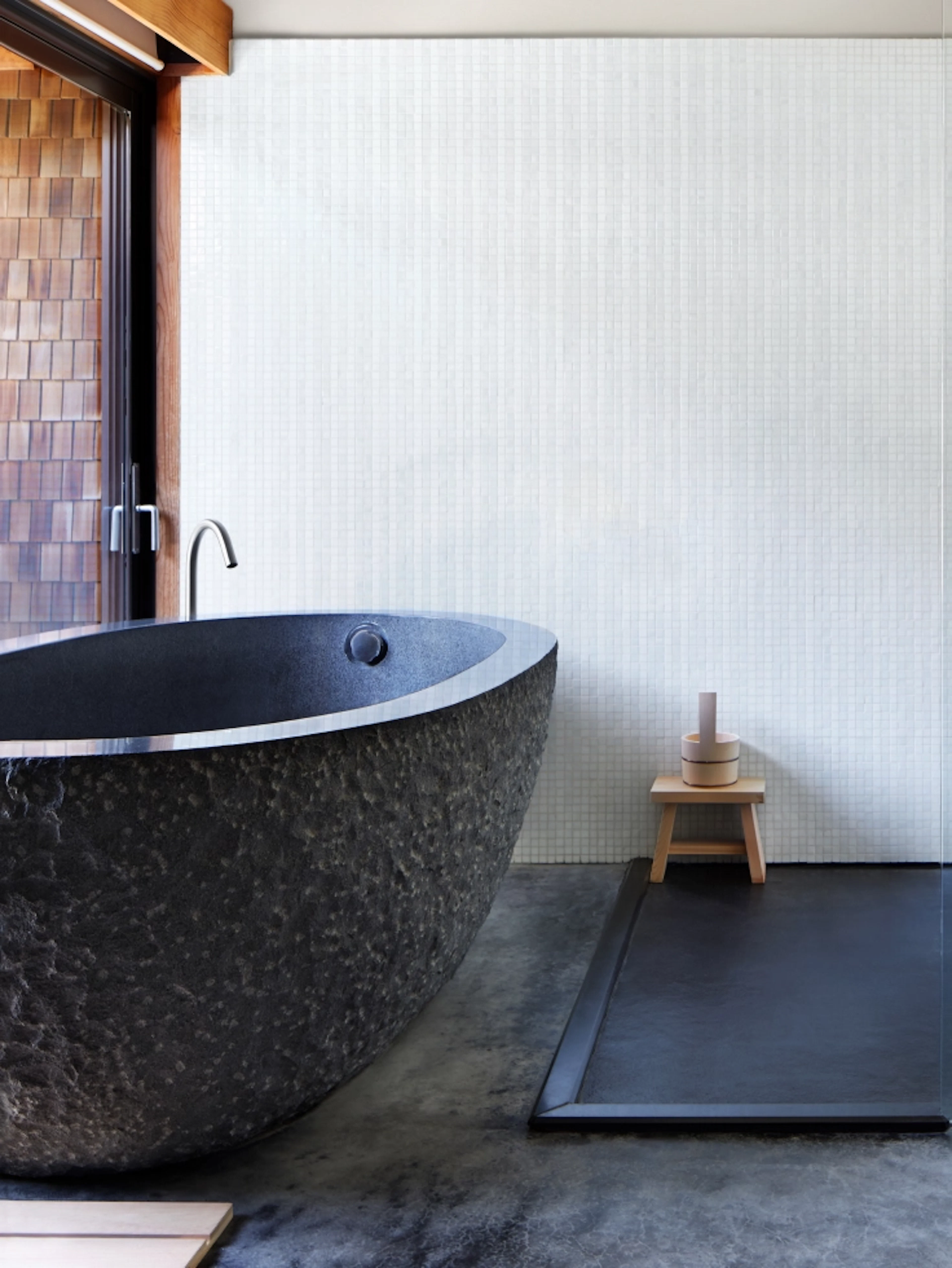 Dark stone freestanding bathtub in bathroom