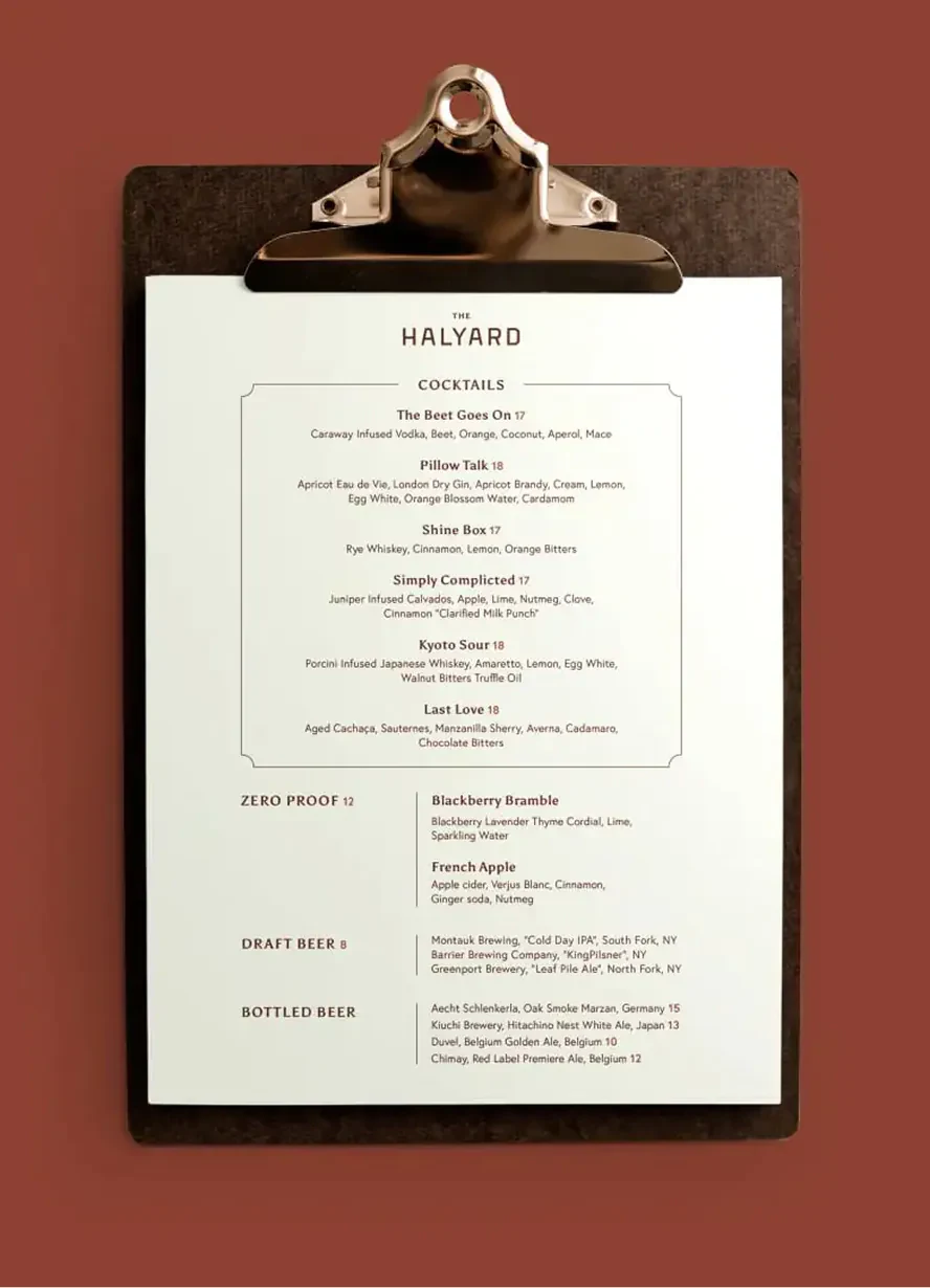 The Halyard cocktail menu clipped to a dark clipboard