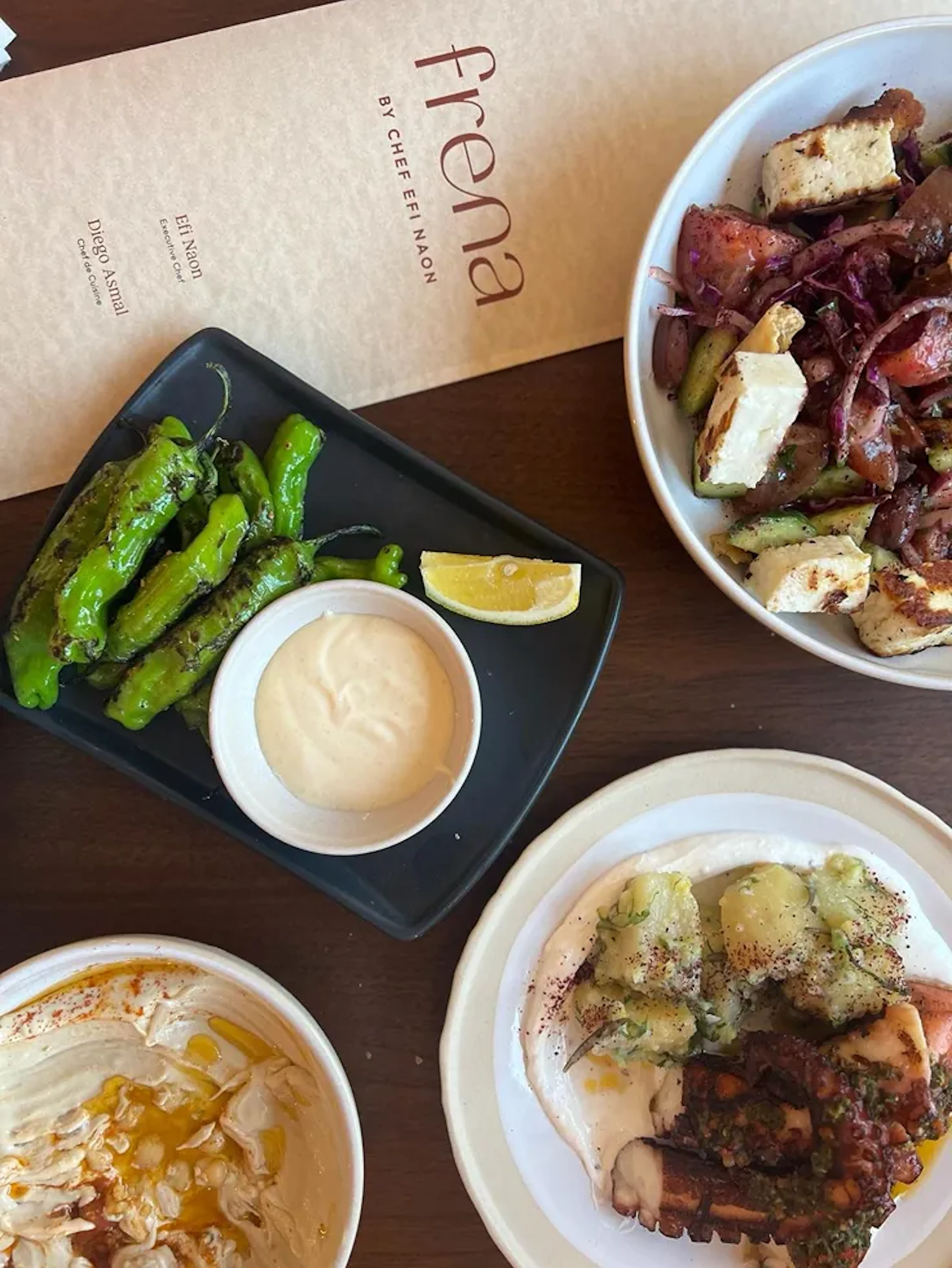 Frena menu and plated dishes on a wood table