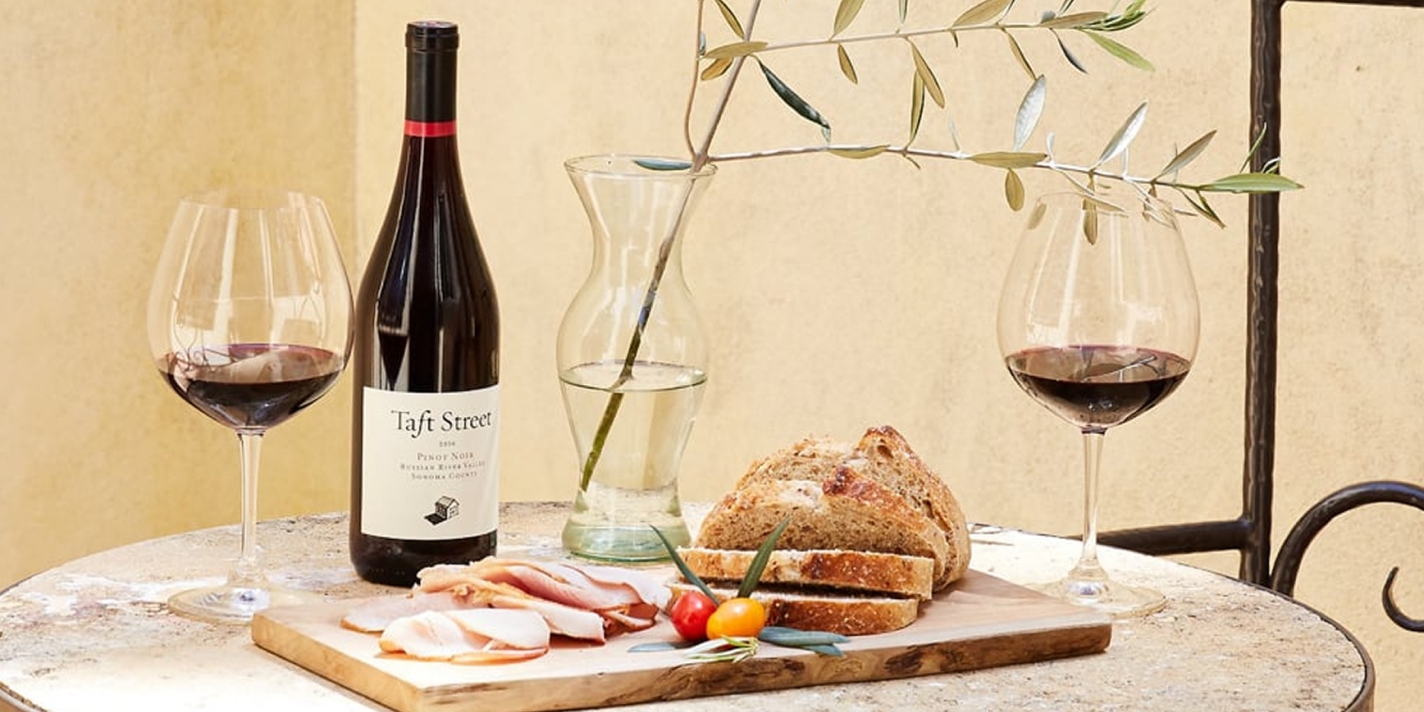 Wine, bread and charcuterie on outdoor table
