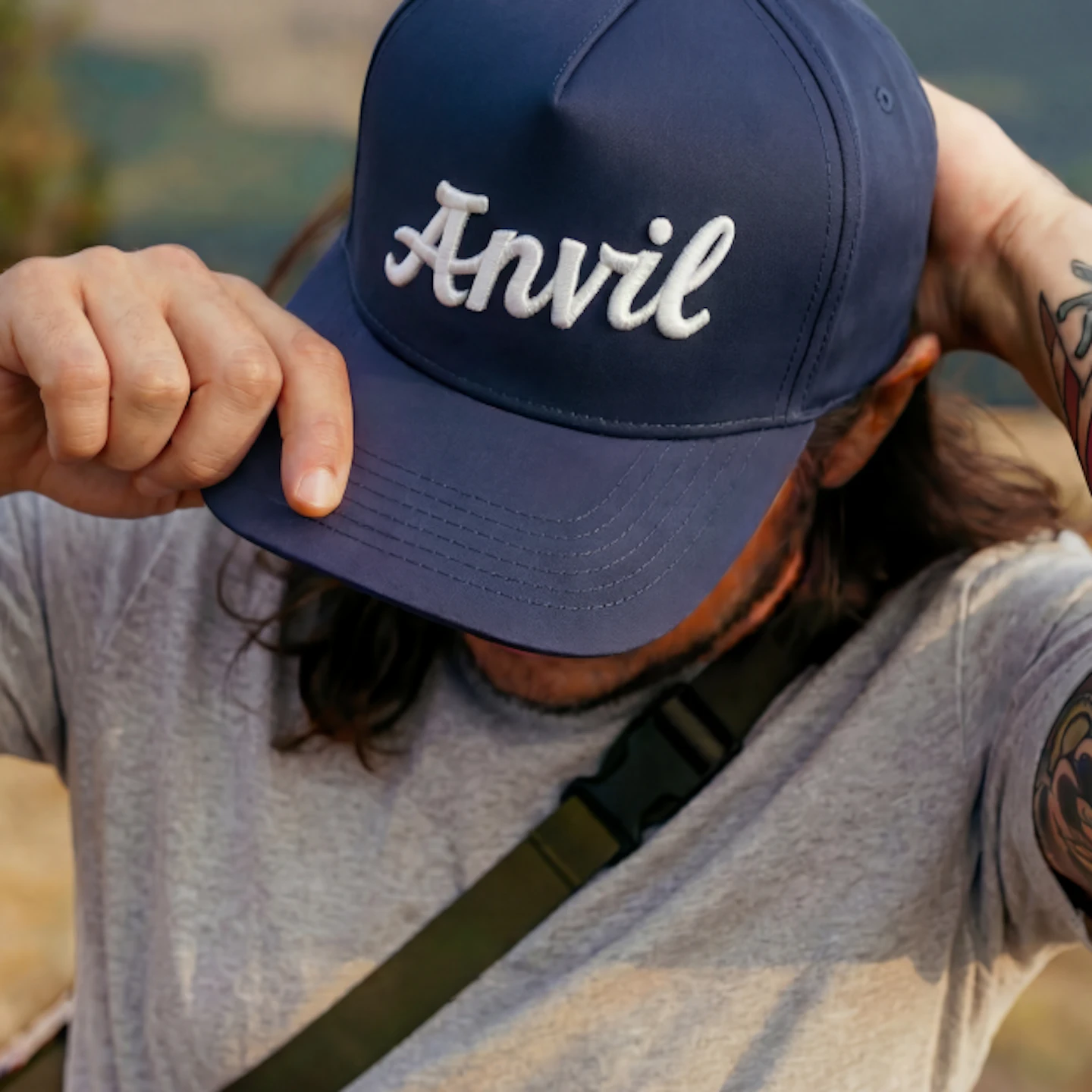 Man wearing a navy Anvil baseball cap