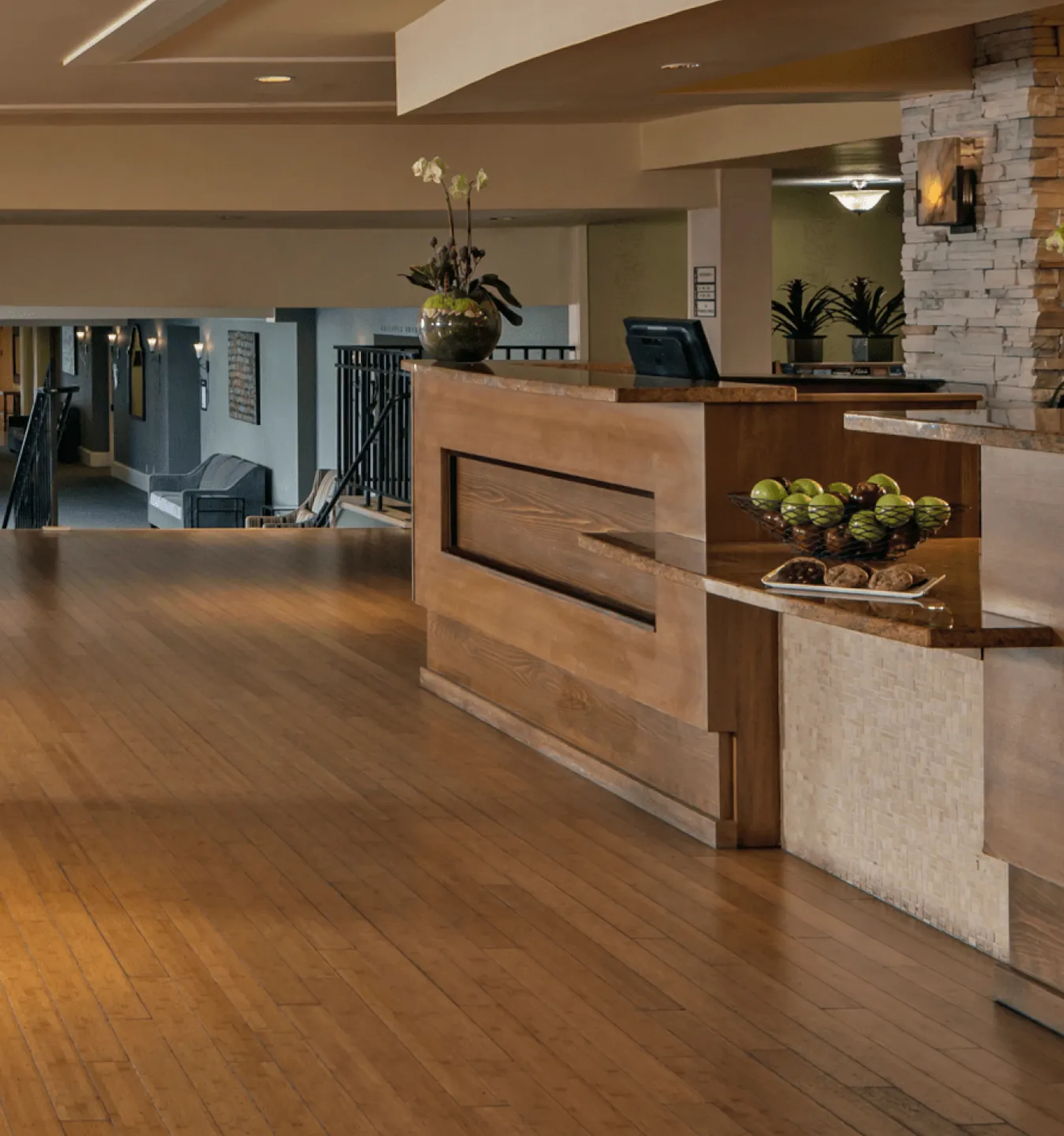 Hotel lobby reception desk with wood floors and stone accent wall