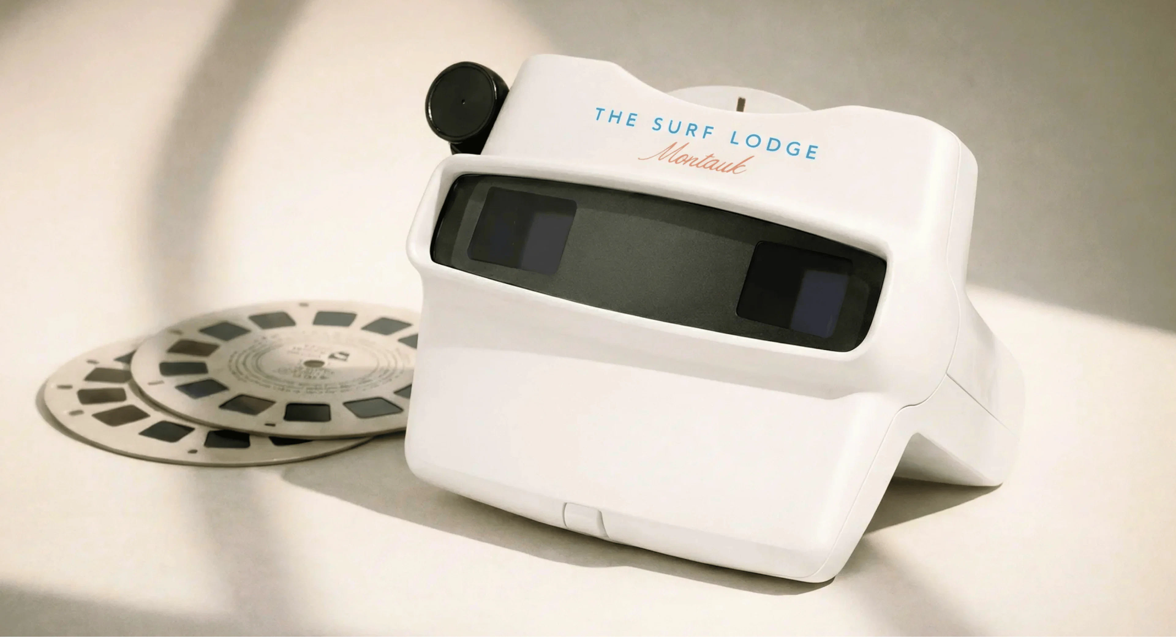 The Surf Lodge branded toy viewfinder with reel beside it